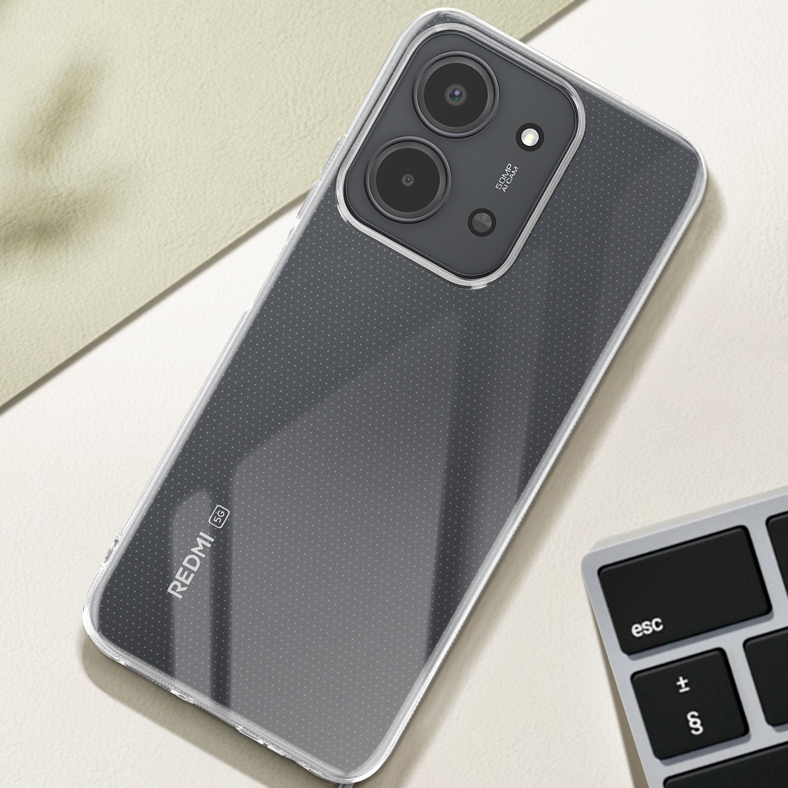 Un téléphone dans un étui repose sur une surface claire. Un clavier est en arrière-plan.