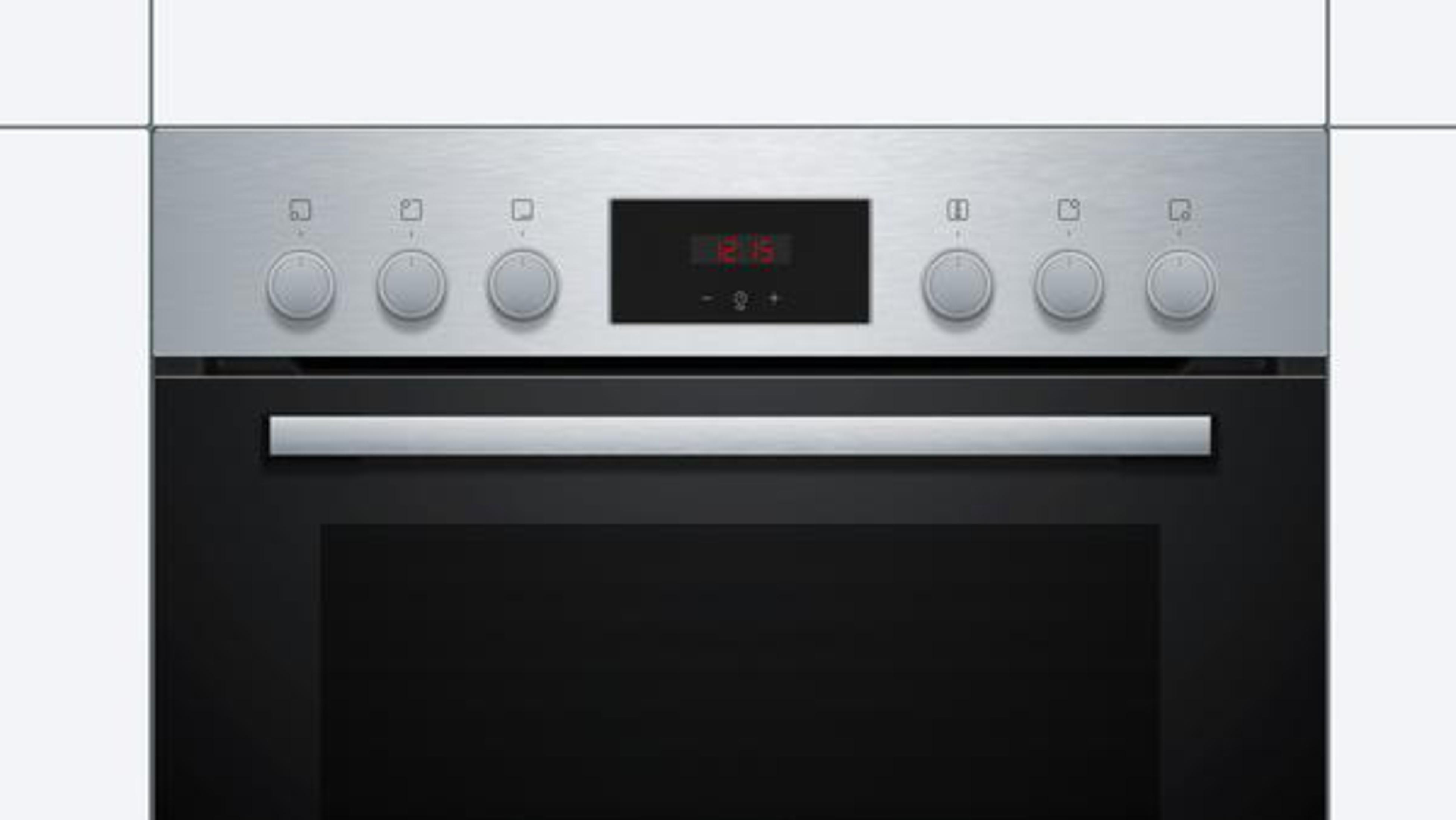 Ein Edelstahl-Backofen mit Knöpfen, Digitaluhr (12:15) und schwarzer Ofentür.