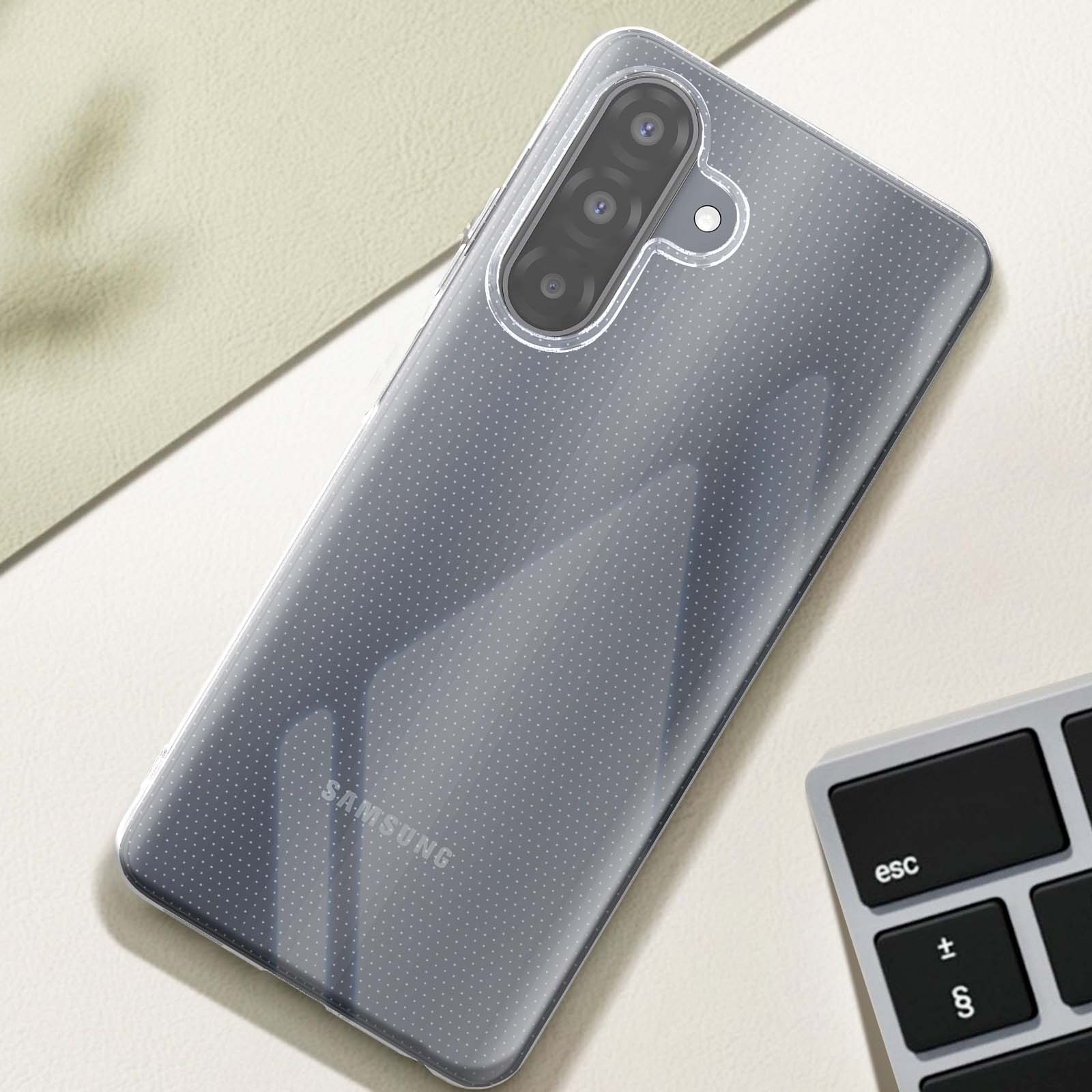 Une coque de téléphone transparente sur une surface claire. Un clavier est à droite.