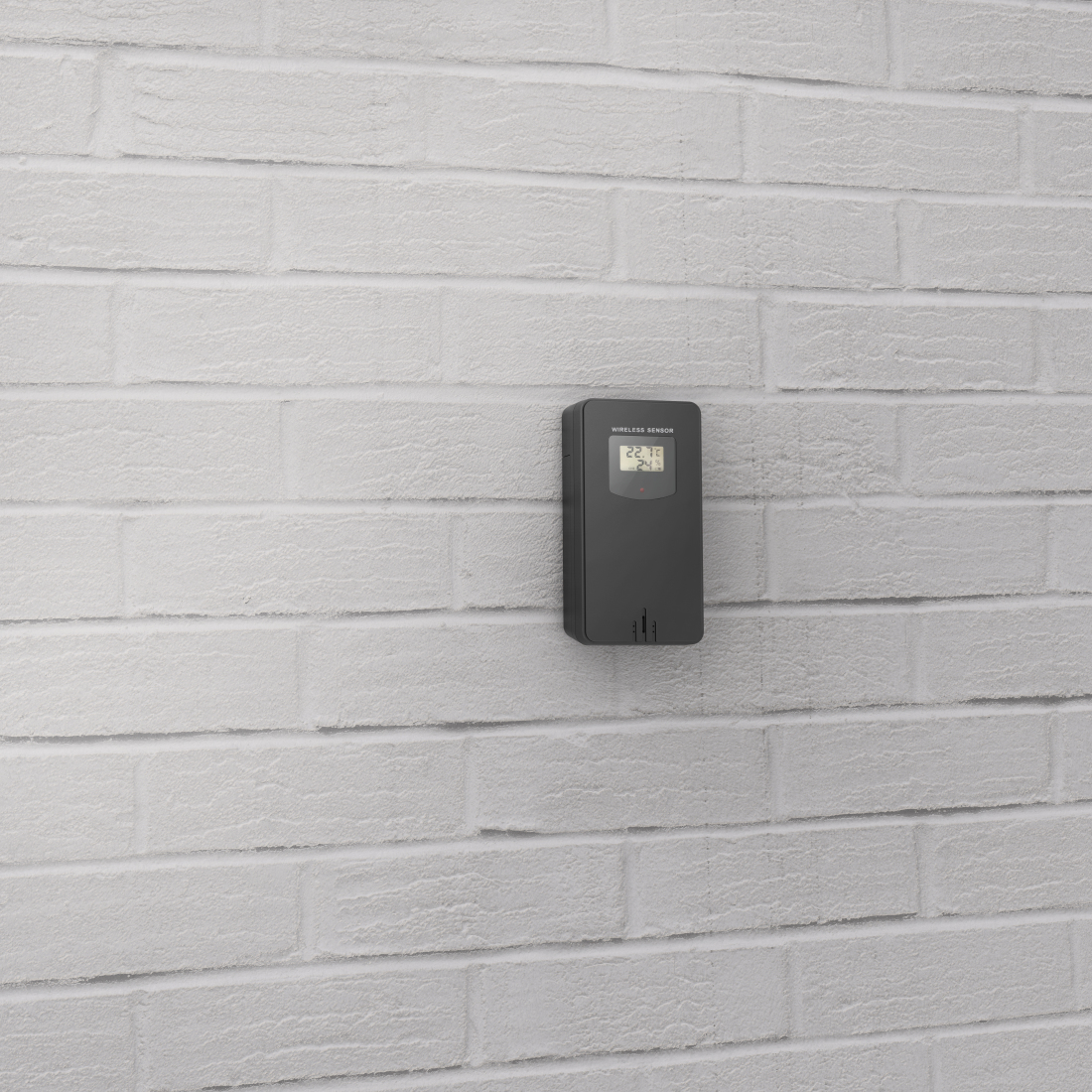 Szary czujnik bezprzewodowy zamontowano na białej ceglanej ścianie. Czujnik wyświetla odczyty temperatury. Ściana jest równomiernie oświetlona.