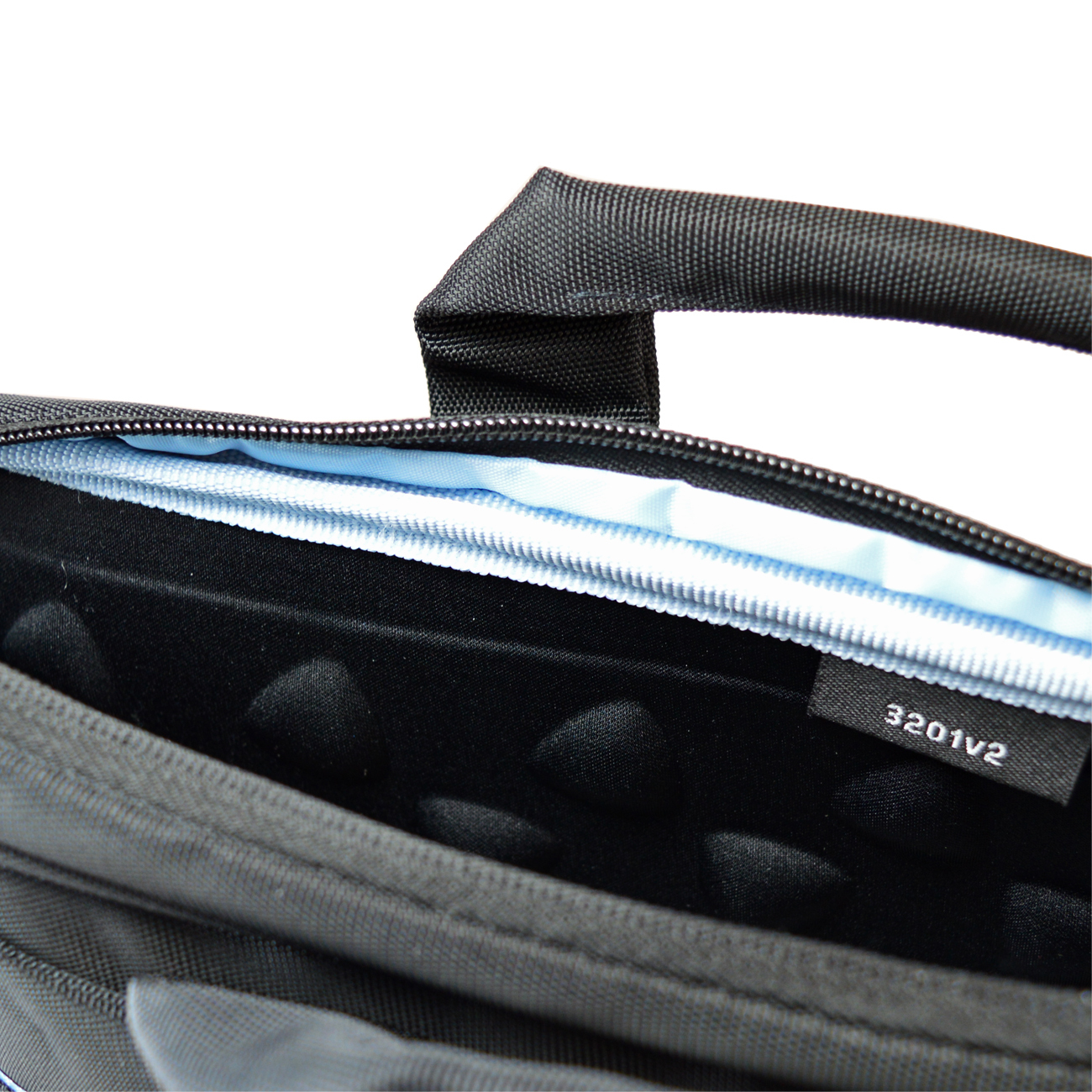 Nahaufnahme einer schwarzen Laptoptasche. Der Griff befindet sich oben. Der Reißverschluss ist geöffnet und zeigt blaues Futter und einen schwarzen Innenraum.