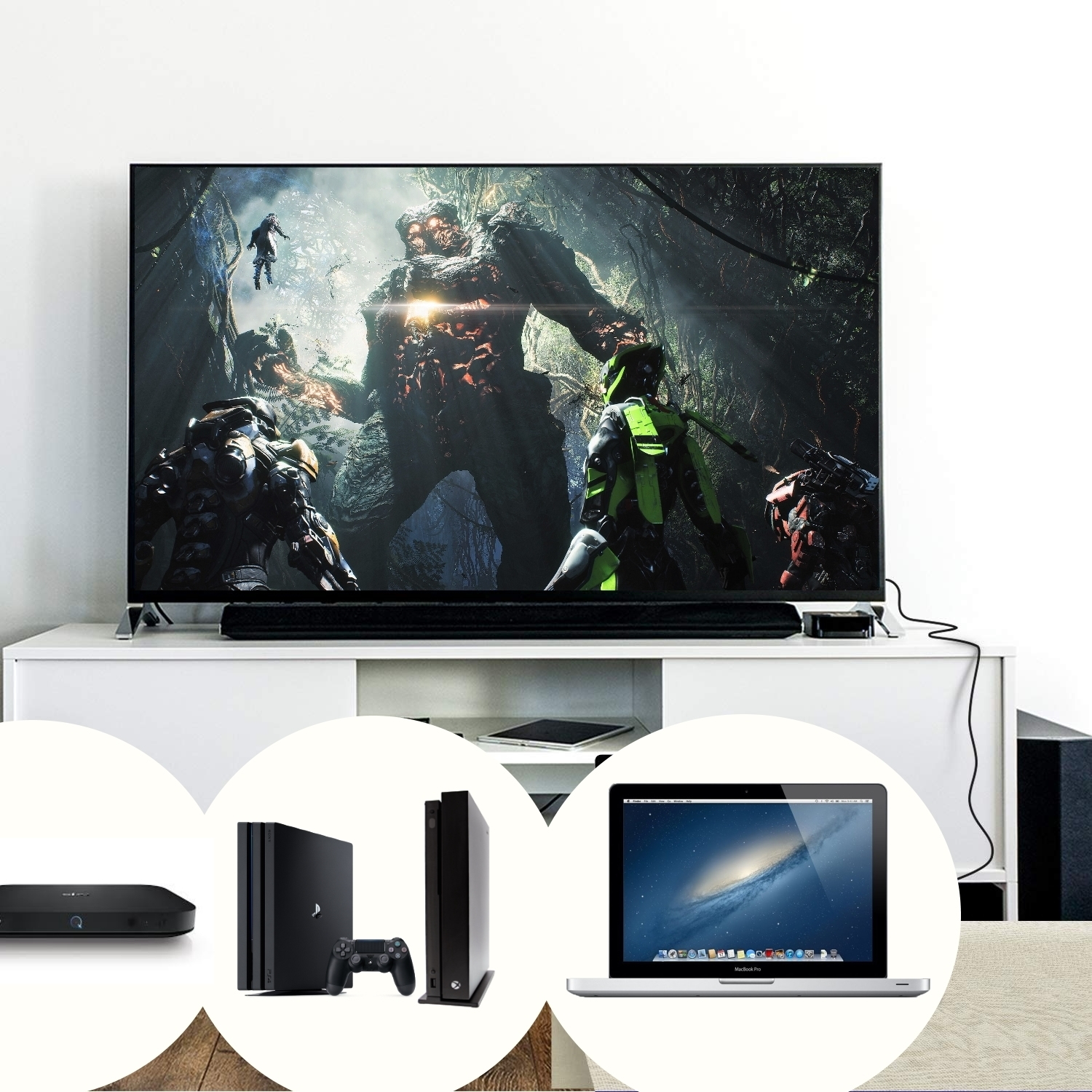 Un televisor muestra una escena de videojuego. Debajo, un portátil, consolas de juegos y un reproductor multimedia.