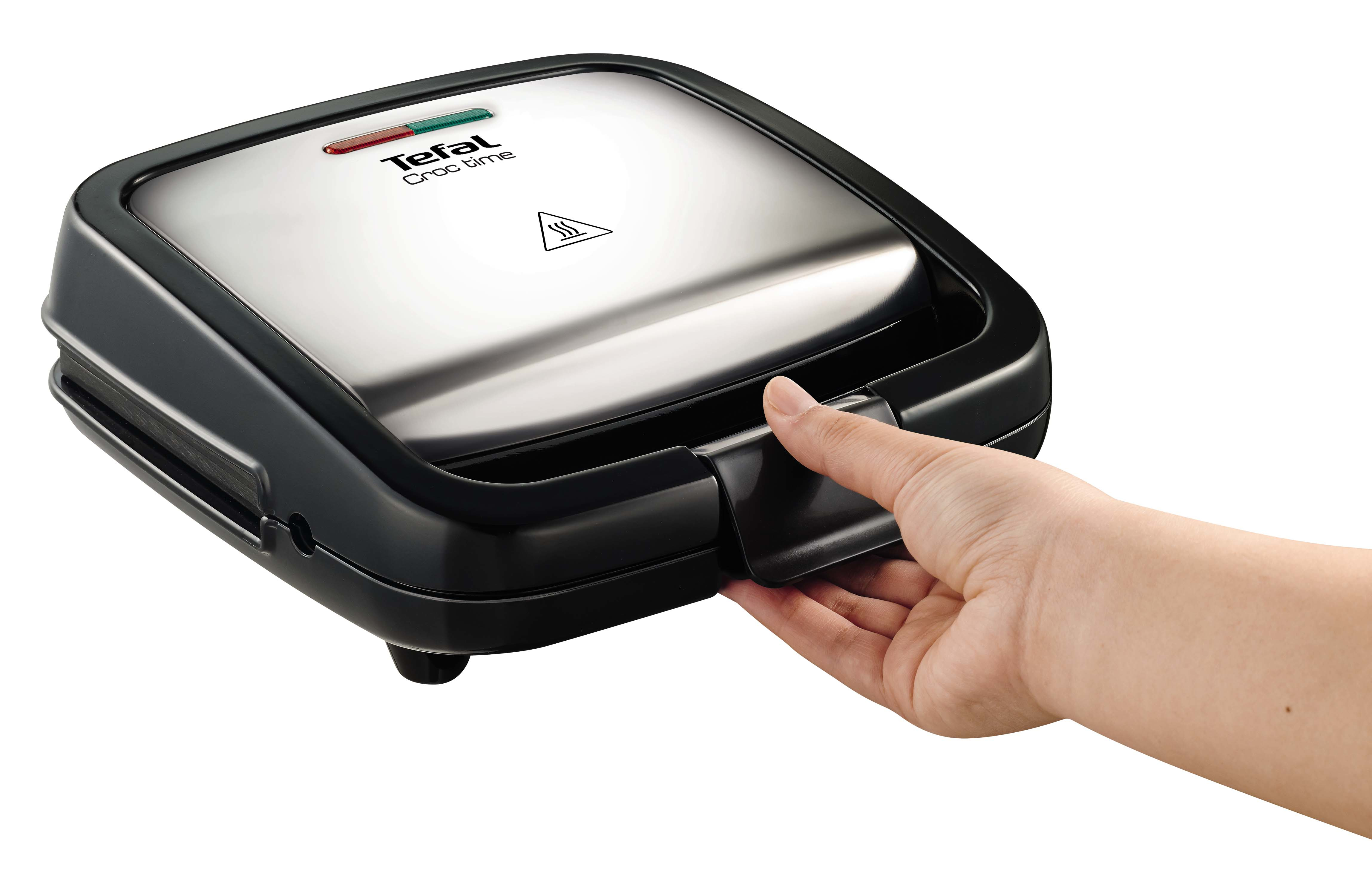 Una macchina per sandwich Tefal Croc time. Una mano apre la maniglia nera. La parte superiore è argentata con luci rosse e verdi.