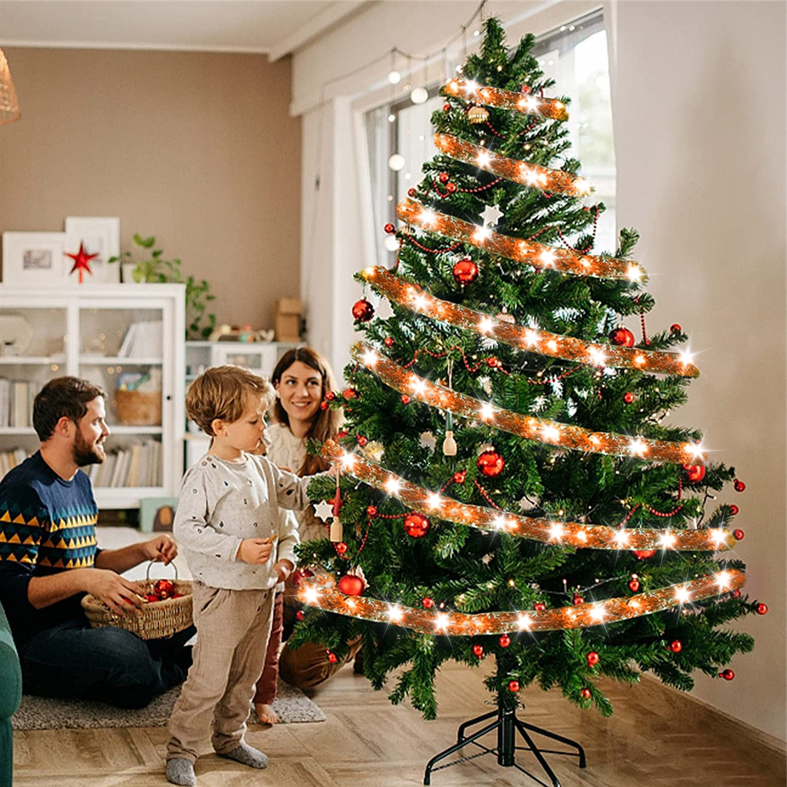 Familie schmückt einen Weihnachtsbaum. Ornamente und Lichter schmücken den grünen Baum. Ein Mann, eine Frau und ein Kind sind im Bild.