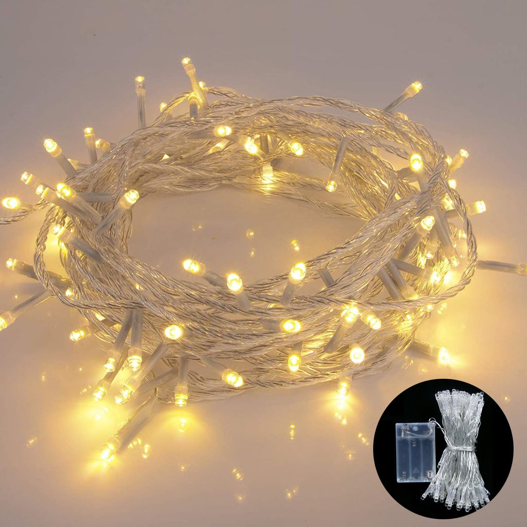 Schnur aus warmweißen LED-Lichtern, auf einer weißen Oberfläche aufgerollt, mit einem Akkupack in der Ecke.