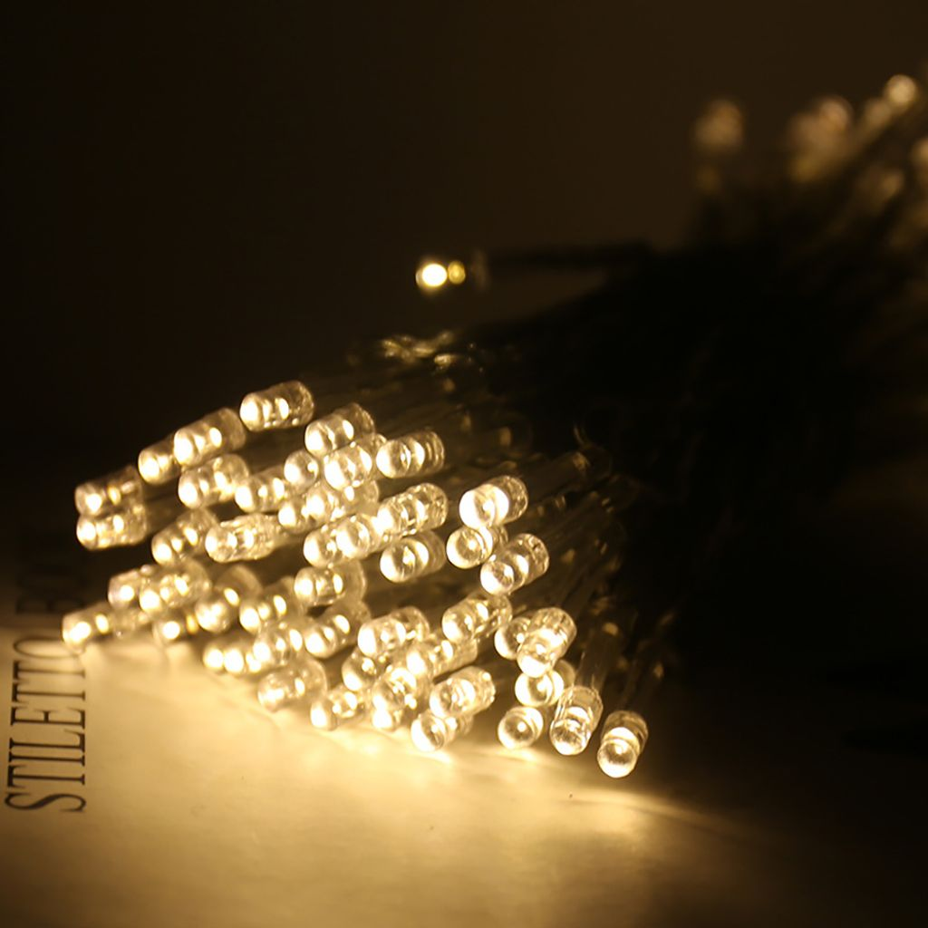 Nahaufnahme von Lichterketten. Viele kleine, leuchtende Lichter sind vor dunklem Hintergrund gruppiert, was auf eine Nachtszene hindeutet.