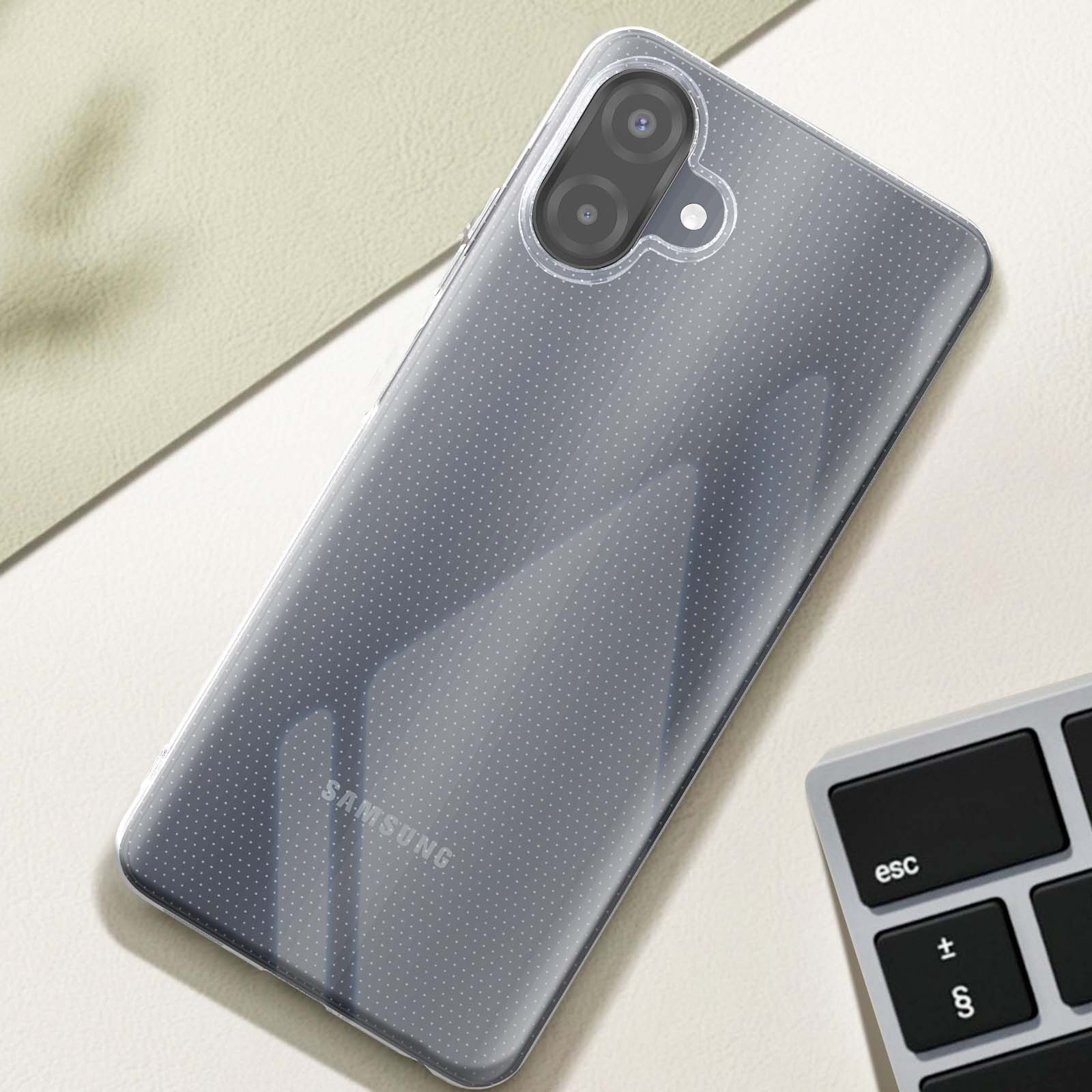 Una funda transparente con un patrón de puntos sobre un teléfono Samsung. Un teclado es visible en la esquina inferior derecha.