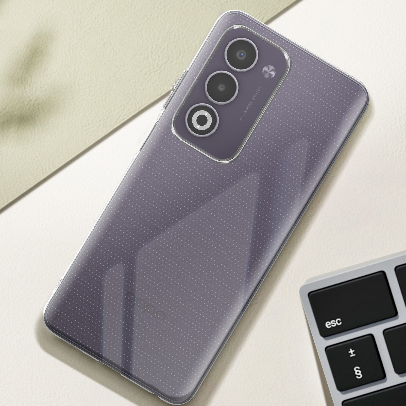 Un telefono in una custodia trasparente è appoggiato su una superficie con una tastiera. Il telefono ha più fotocamere.