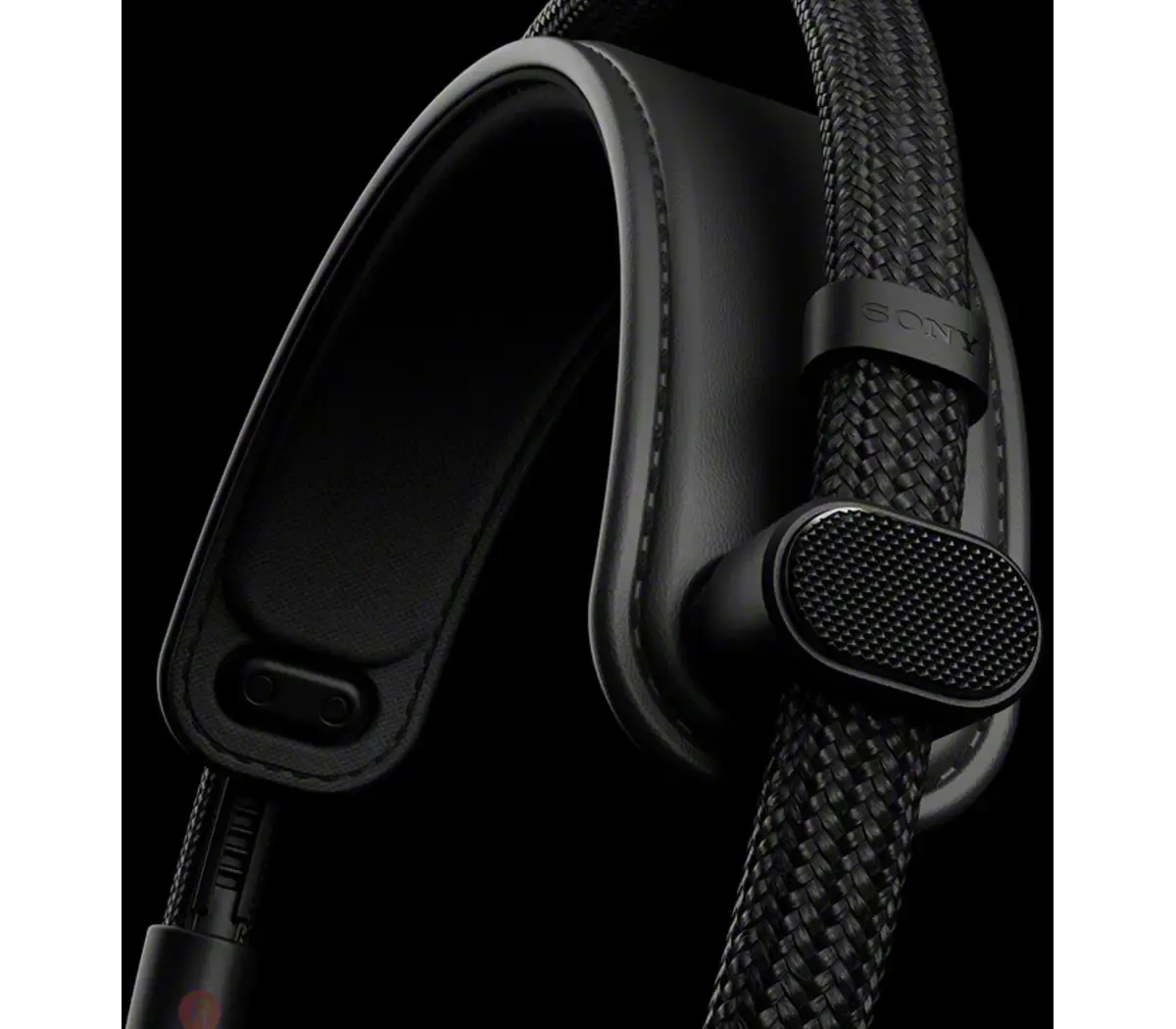 Gros plan sur un casque noir avec un câble tressé. Le logo Sony est visible. Le fond est noir.