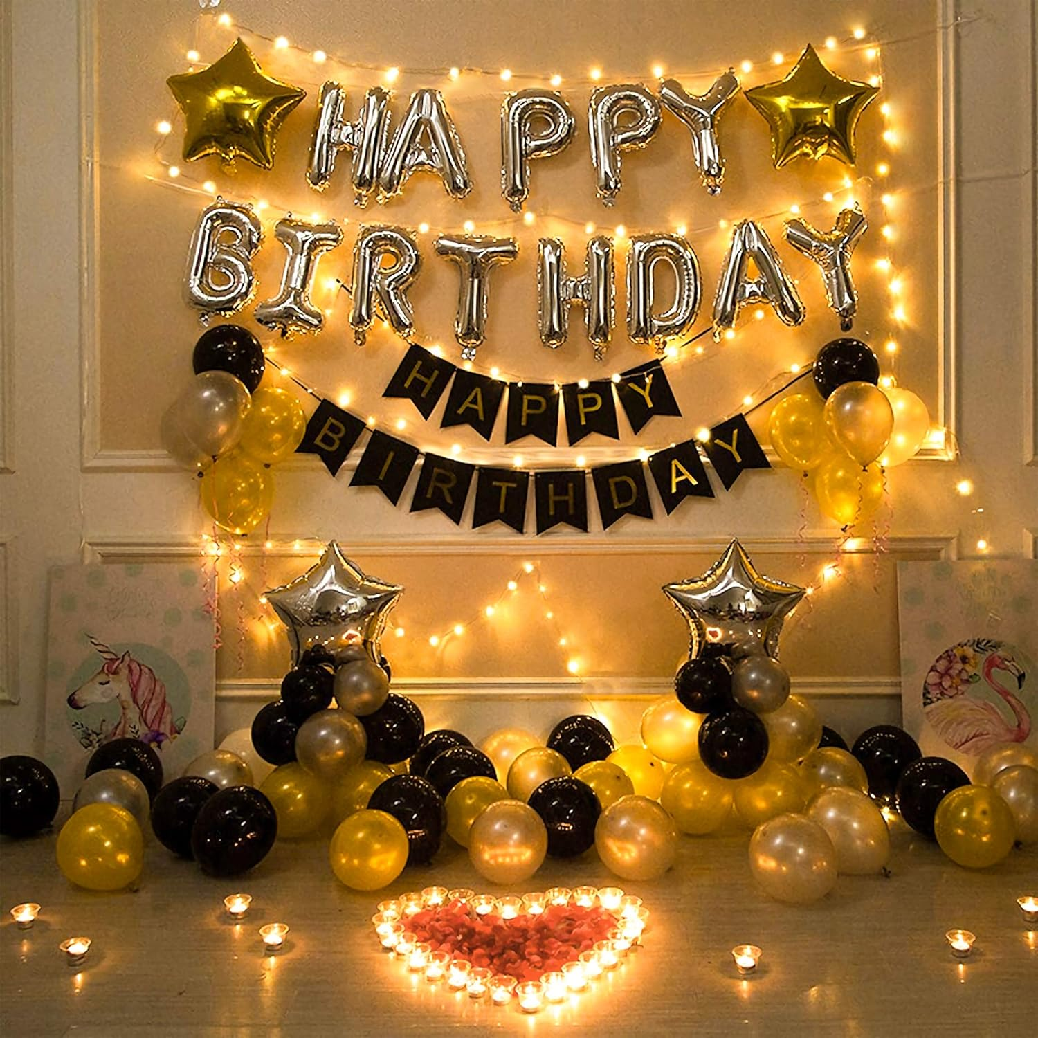 Ein Geburtstags-Hintergrund mit silbernen Ballons, die 'Happy Birthday' schreiben. Goldene und schwarze Ballons schmücken die Szene. Kerzen und Lichterketten.
