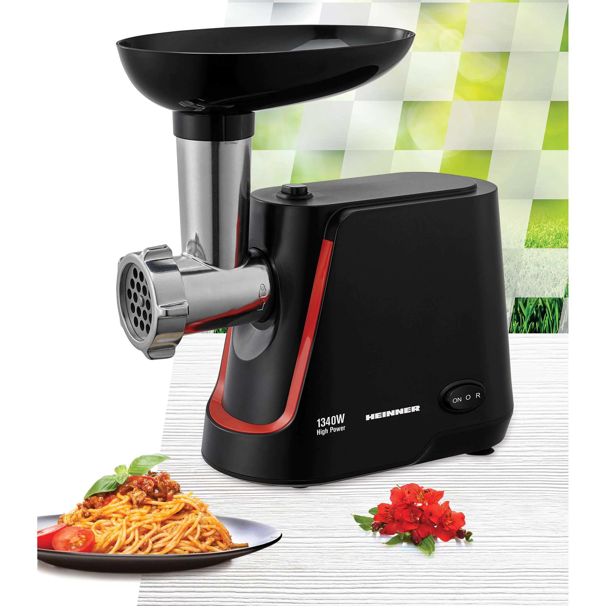 Black meat grinder with red accents, spaghetti with meat sauce, and red flowers on a white wood-like surface.