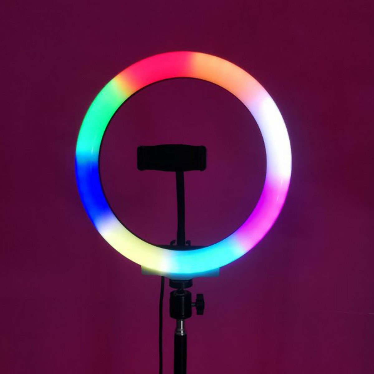 Ein farbenfrohes Ringlicht mit Telefonhalter steht vor einem lila Hintergrund auf einem Ständer.