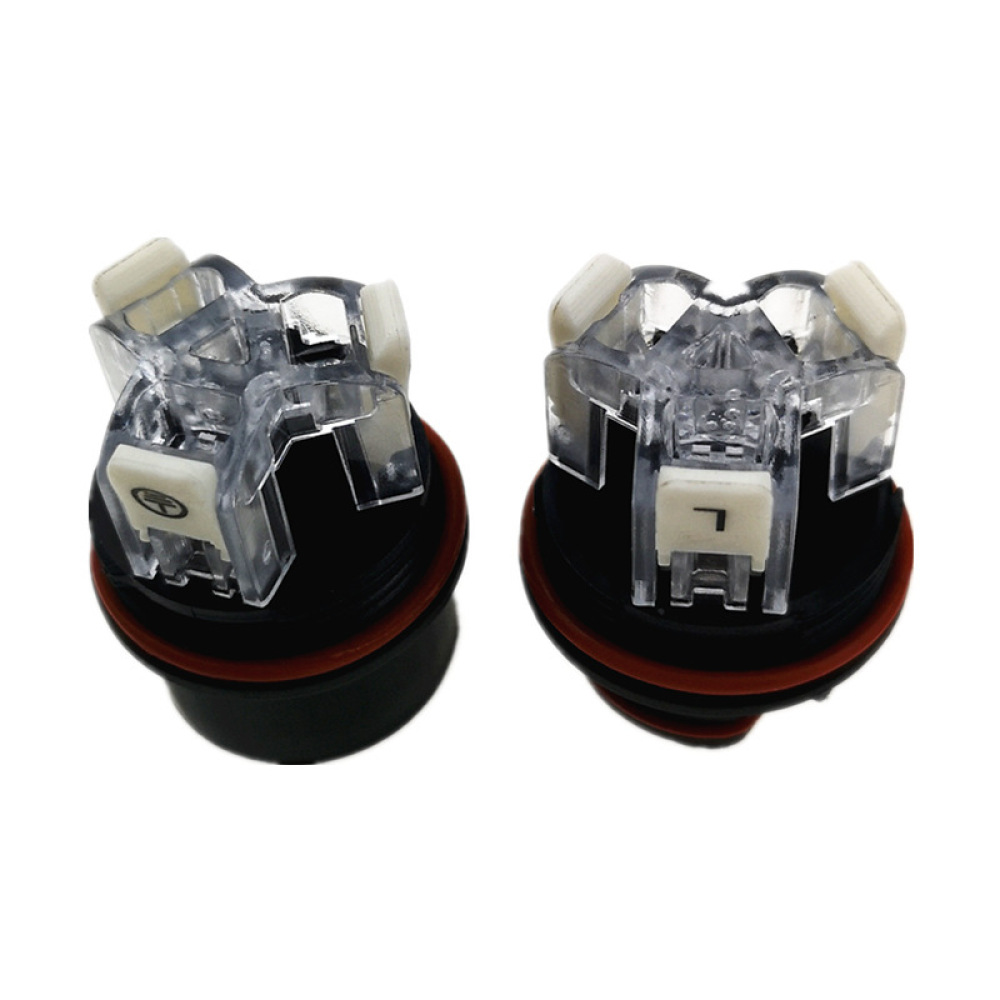 Zwei transparente Kunststoff-Autolampen. Jede hat einen schwarzen Sockel mit rotem Ring. Eine hat ein 'L'.
