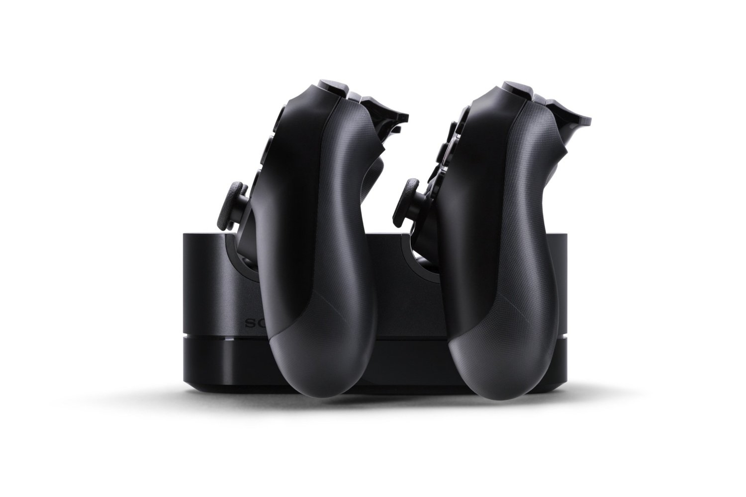 Zwei schwarze Gamecontroller sind auf einer schwarzen Ladestation angedockt, vor weißem Hintergrund. Die Controller stehen nebeneinander.