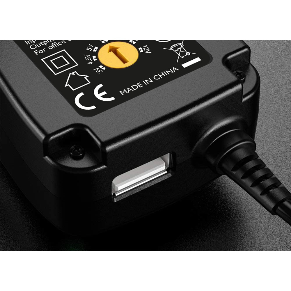 Czarna ładowarka z portem USB, znakiem CE i etykietą Made in China. Ikona żółtej strzałki. Zbliżenie z gradientowym tłem.