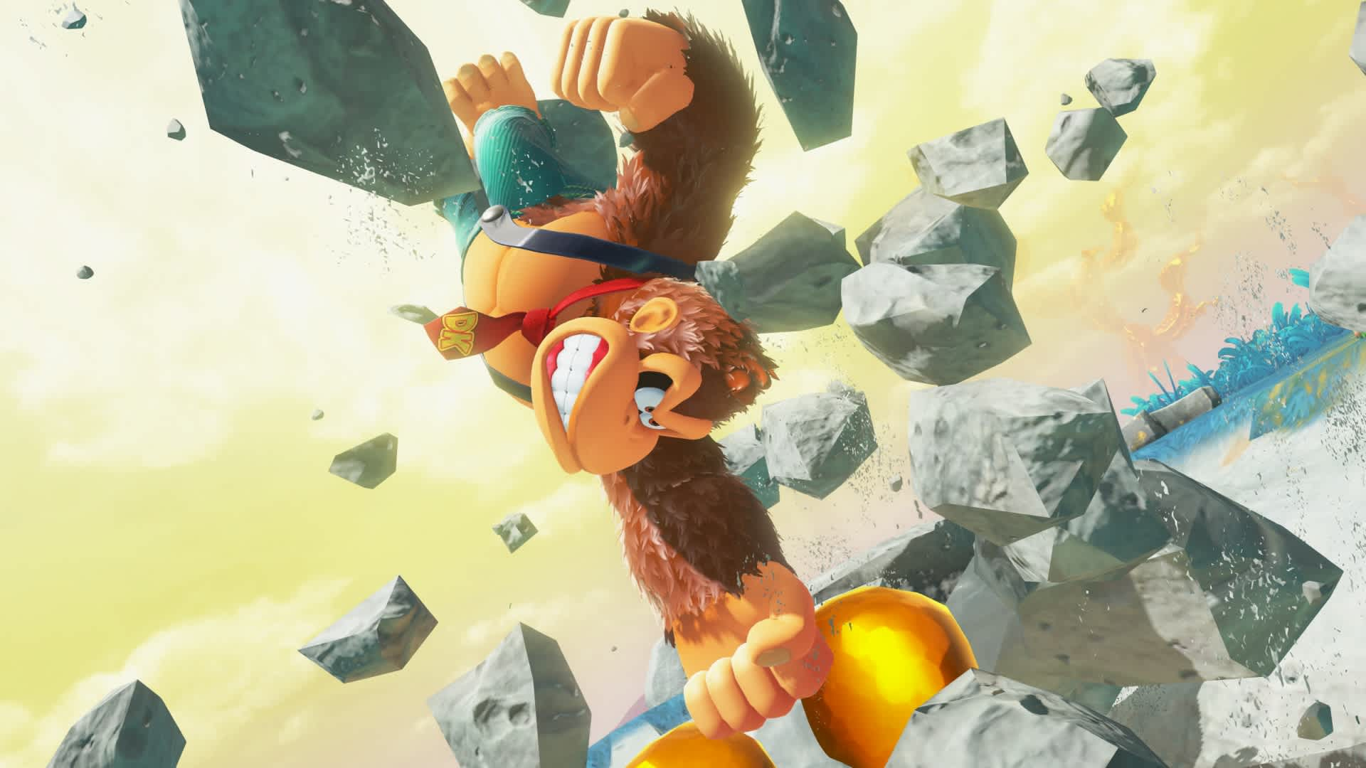 Donkey Kong w powietrzu, otoczony fragmentami skał, żółte i niebieskie tło. Nosi czerwony krawat i niebieską koszulę.