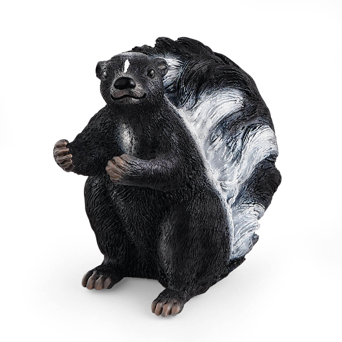 Figurka skunksa. Jest czarny z białym paskiem na grzbiecie i głowie. Siedzi wyprostowany ze złączonymi łapami.