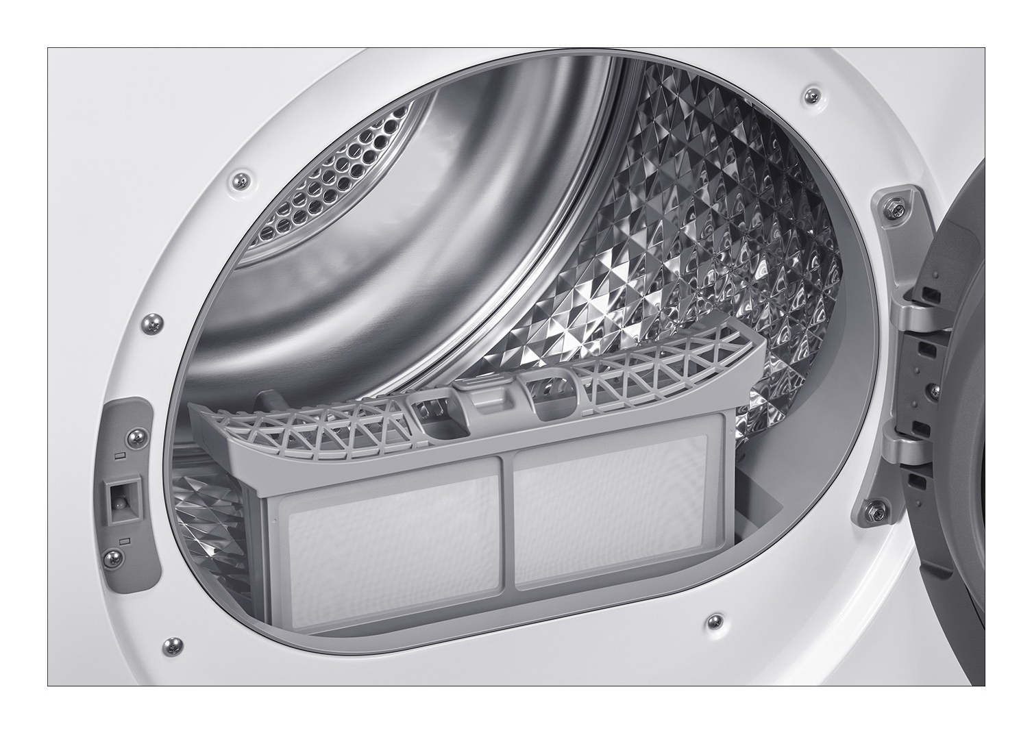 Wnętrze suszarki z wyjętym filtrem. Bęben jest srebrny. Biało-szary filtr znajduje się na środku.