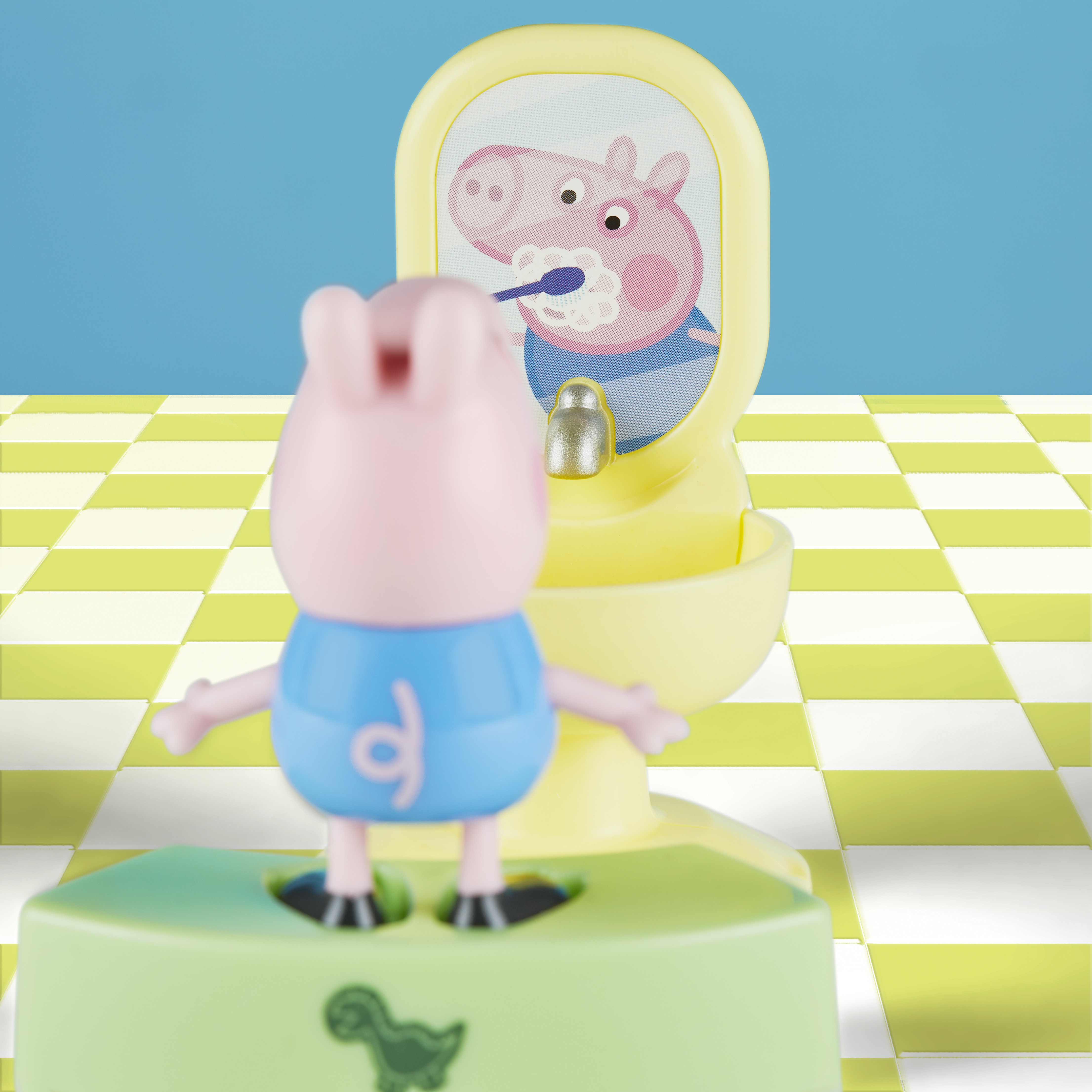 Un giocattolo di Peppa Pig si guarda allo specchio. Lo specchio mostra Peppa Pig che si lava i denti. Pavimento verde e bianco.