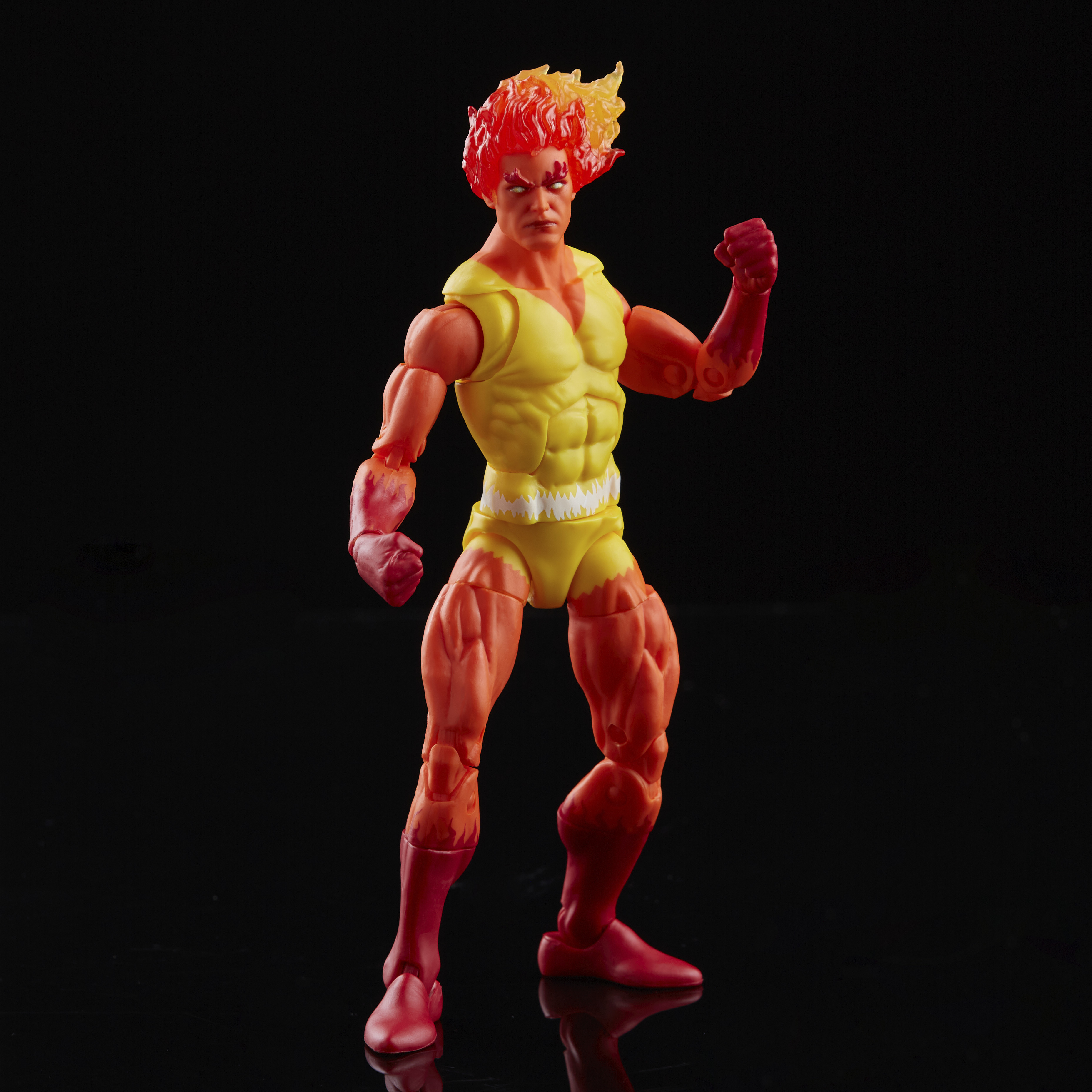 Una figura di supereroe con testa infuocata e pelle arancione. Indossa un completo giallo ed è in posa da combattimento.