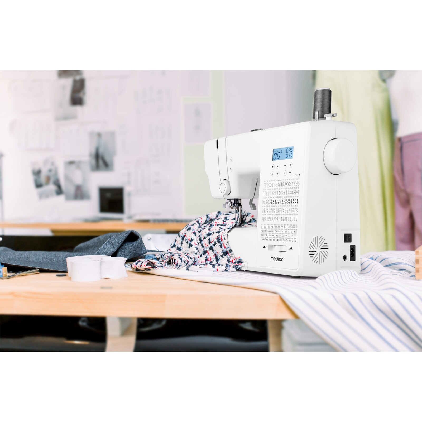 Biała maszyna do szycia z tkaniną na drewnianym stole. Obecne są również inne materiały i deska do szycia.