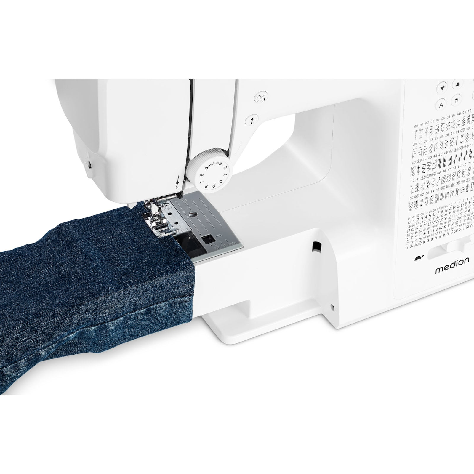 Biała maszyna do szycia z niebieskim dżinsem pod igłą. Widoczna tarcza i wzory ściegów.