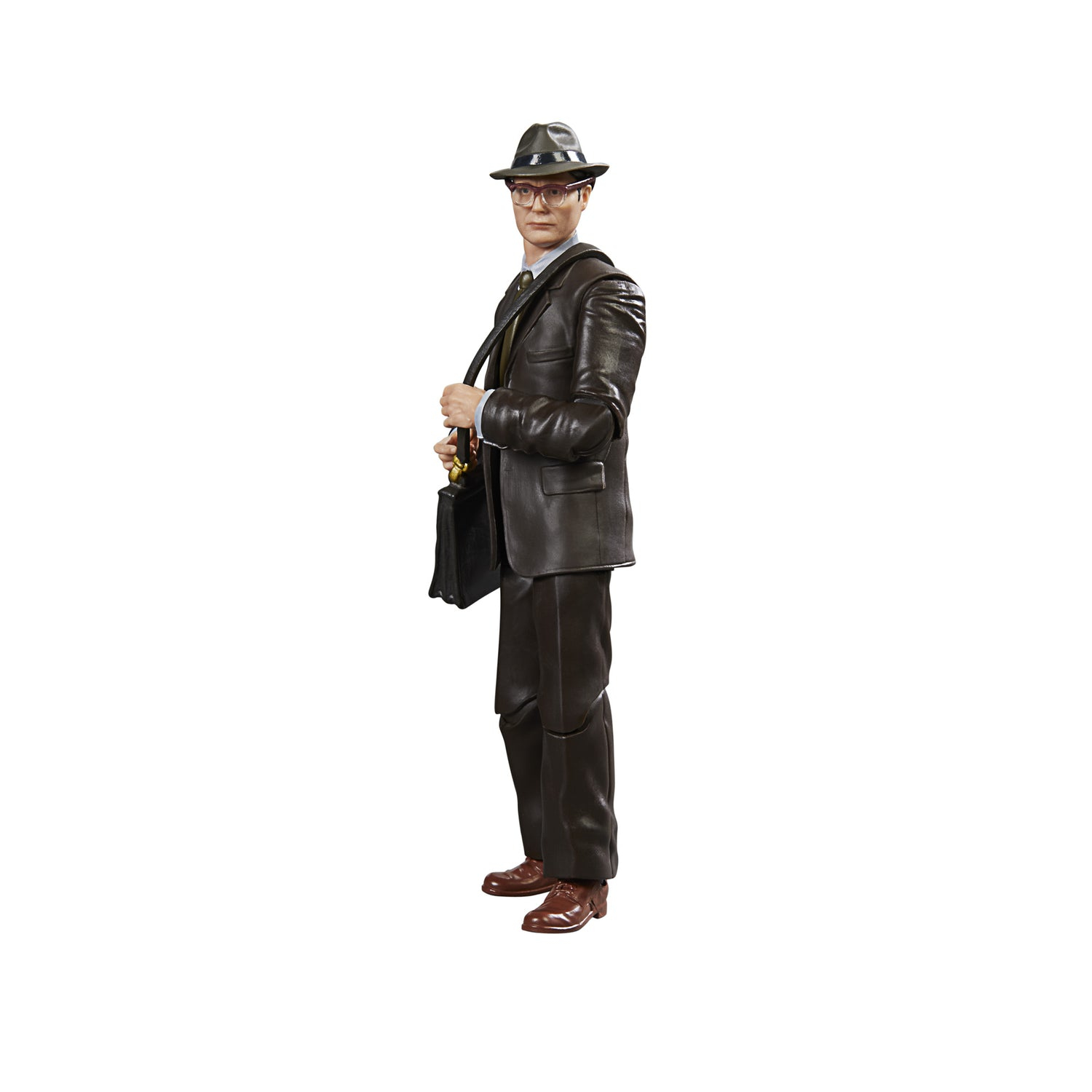 Un uomo in abito marrone, cappello e occhiali tiene una valigetta. Si trova su sfondo bianco.