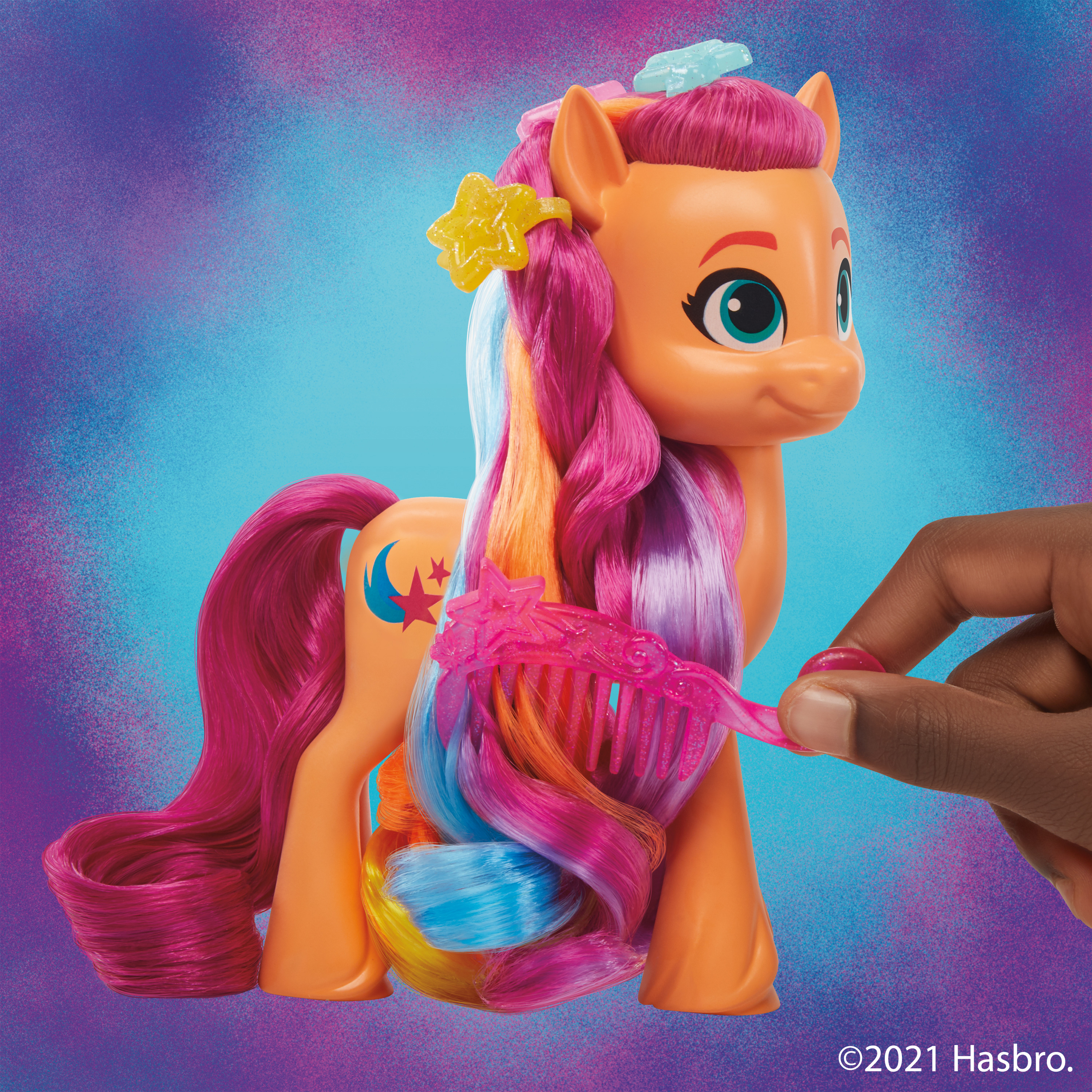 Un pony giocattolo con capelli colorati viene spazzolato da una mano. Lo sfondo è un gradiente di blu e viola.