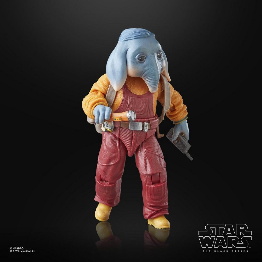 Sarı gömlek ve kırmızı tulum giymiş, fil benzeri kafalı, mavi tenli bir uzaylının Star Wars figürü, aletler tutuyor.