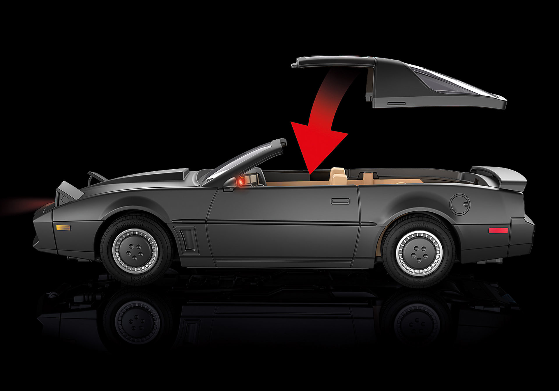 Szary samochód sportowy ze zdejmowanym dachem. Czerwona strzałka pokazuje odłączanie dachu. Czarne tło z odbiciem.