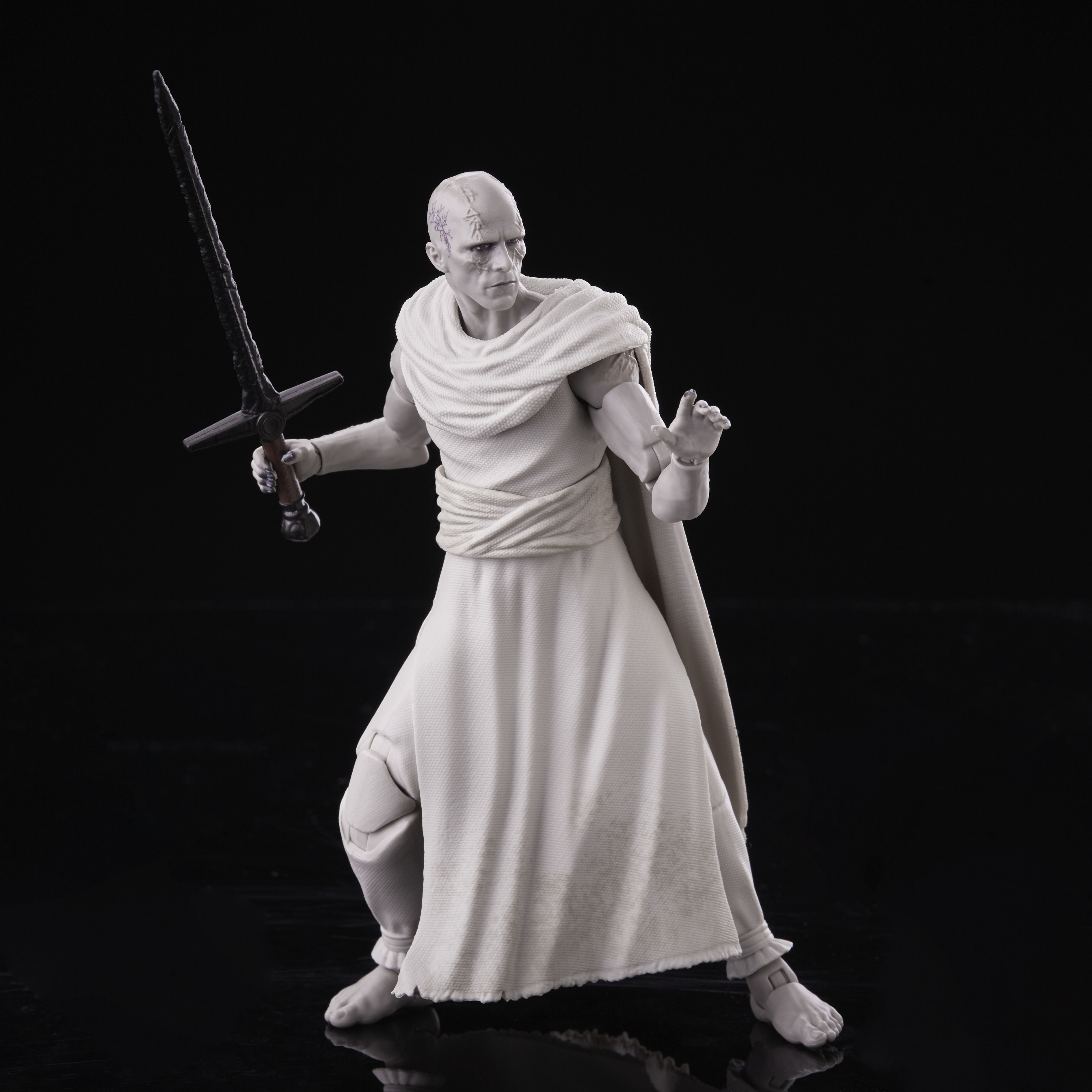 Biała postać trzyma miecz, stojąc na czarnym tle. Postać ma na sobie białą szatę i bliznę.
