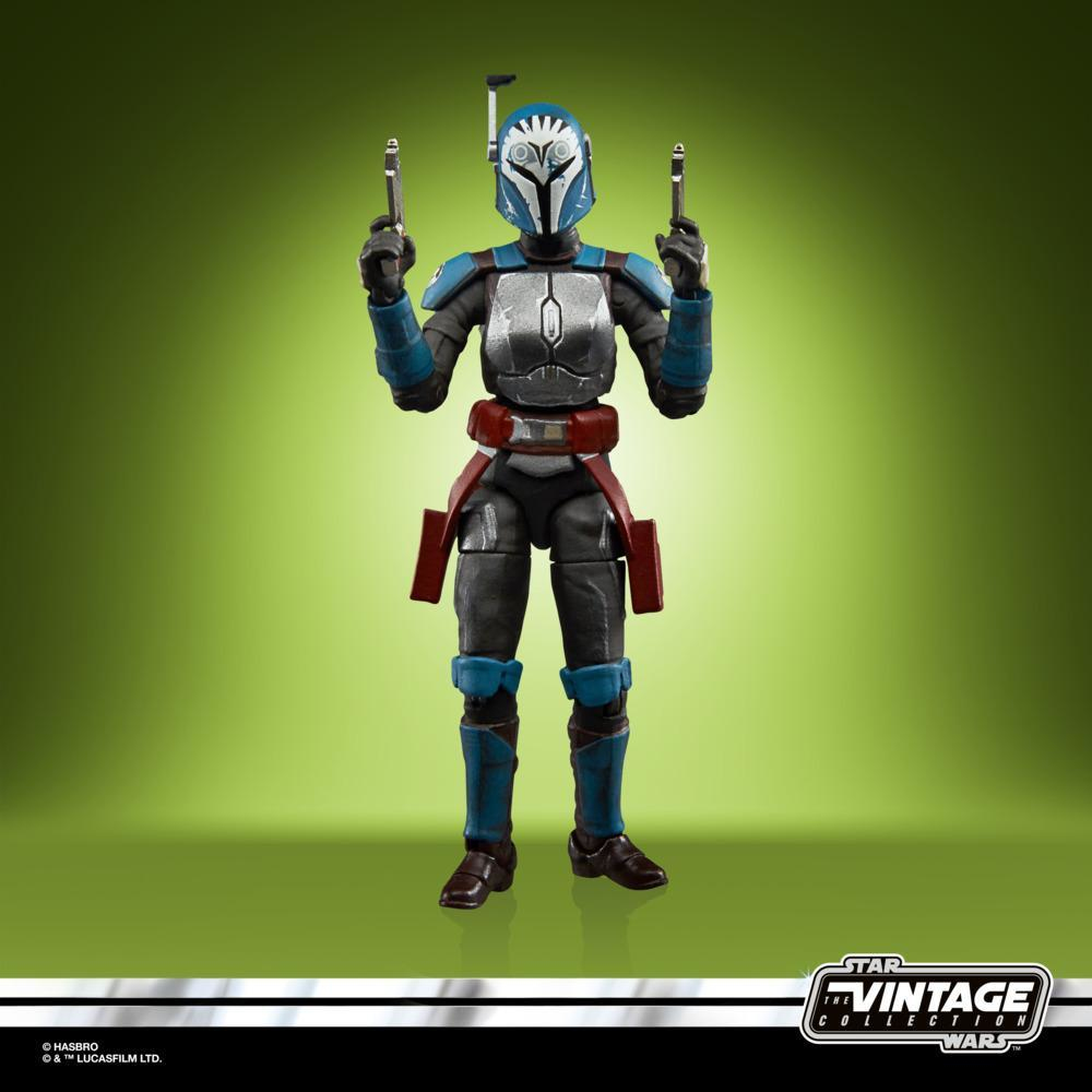 Action figure di Star Wars. La figura mandaloriana è in piedi con le pistole sollevate. Sfondo verde e giallo.