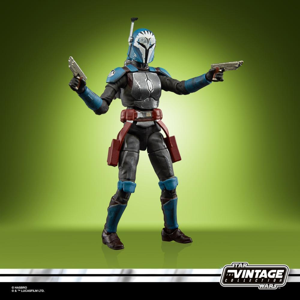 Una figura di Star Wars, un guerriero mandaloriano, in piedi con blaster in mano. Armatura blu e grigia, cintura rossa e sfondo verde.