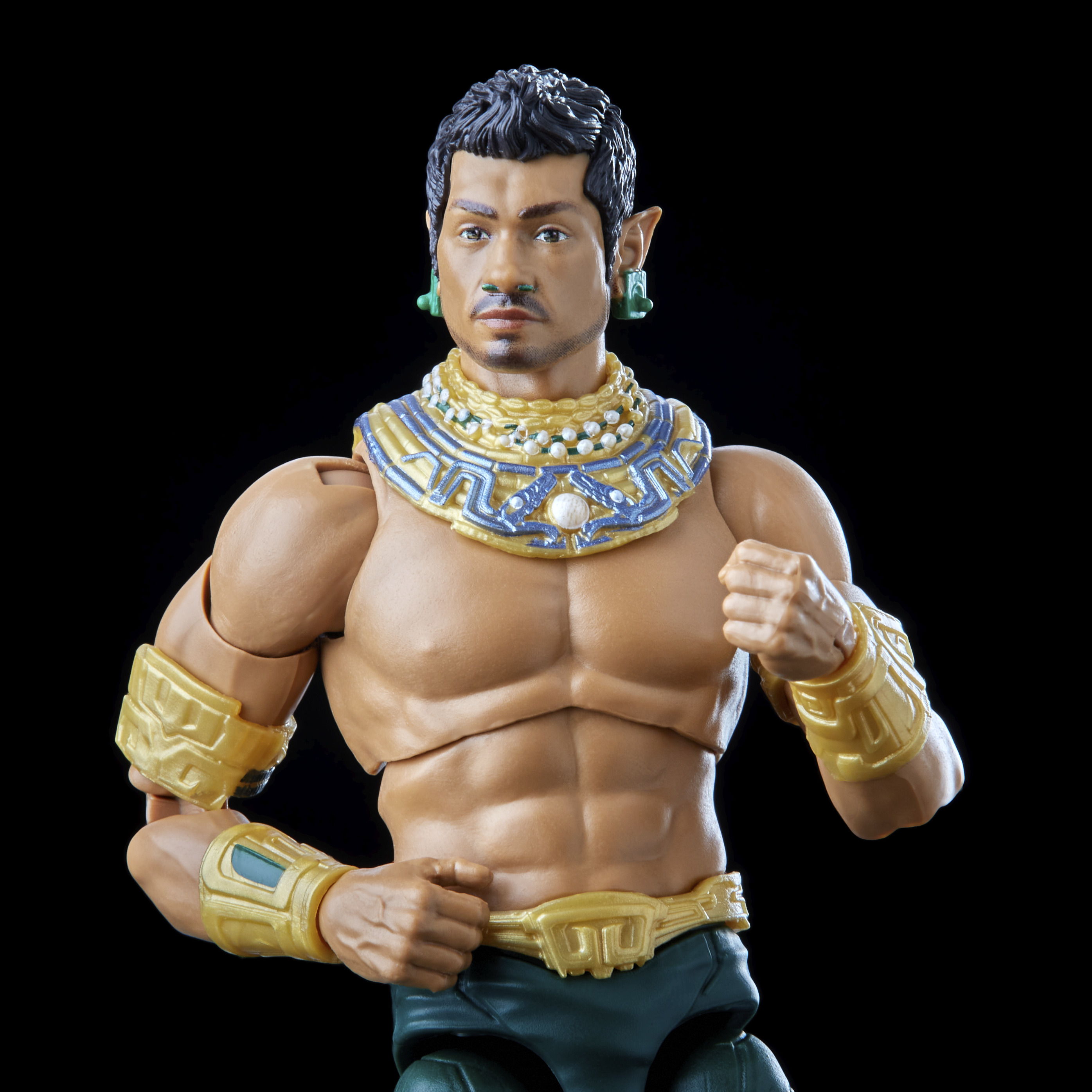 Un action figure maschile con gioielli e armatura, posato su sfondo nero.