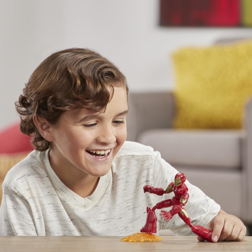 Un ragazzo sorride guardando un giocattolo di Iron Man. Il giocattolo è rosso e oro. Un cuscino giallo è sullo sfondo.