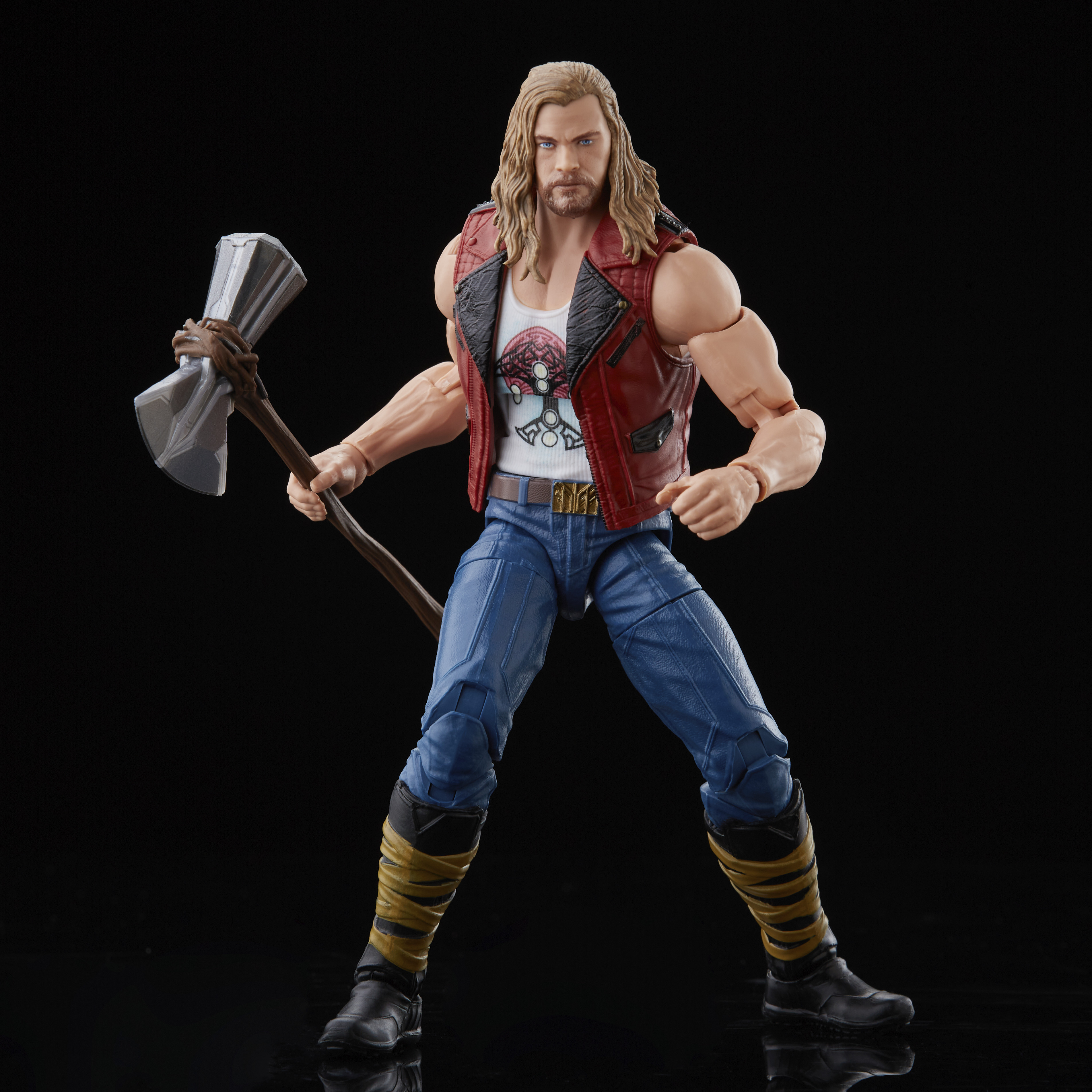 Action figure di Thor con un'ascia d'argento. Indossa gilet rosso, camicia bianca, jeans blu e stivali neri, su sfondo nero.