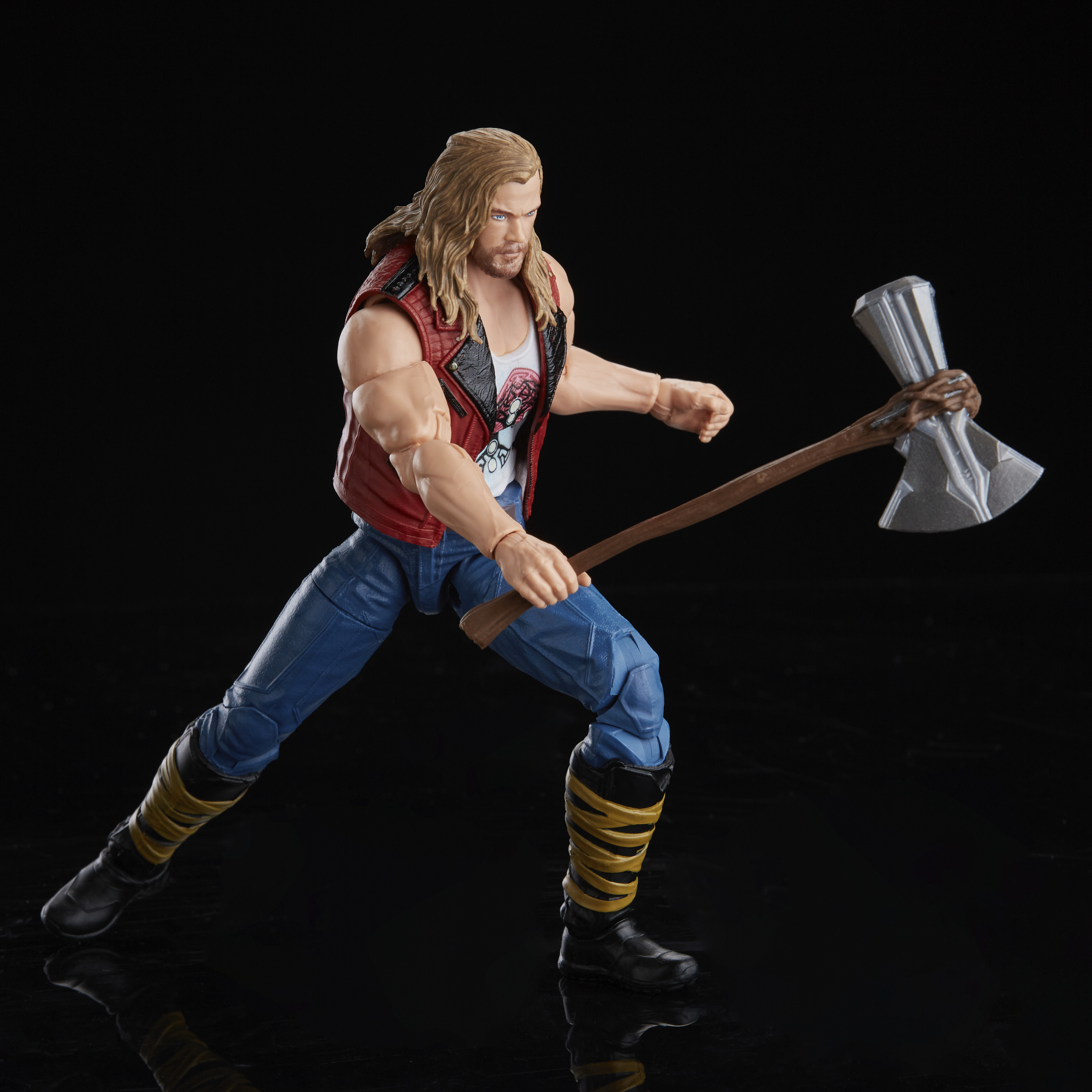 Action figure di Thor, con un'ascia. Indossa un gilet rosso, pantaloni blu e stivali neri. Sfondo nero.