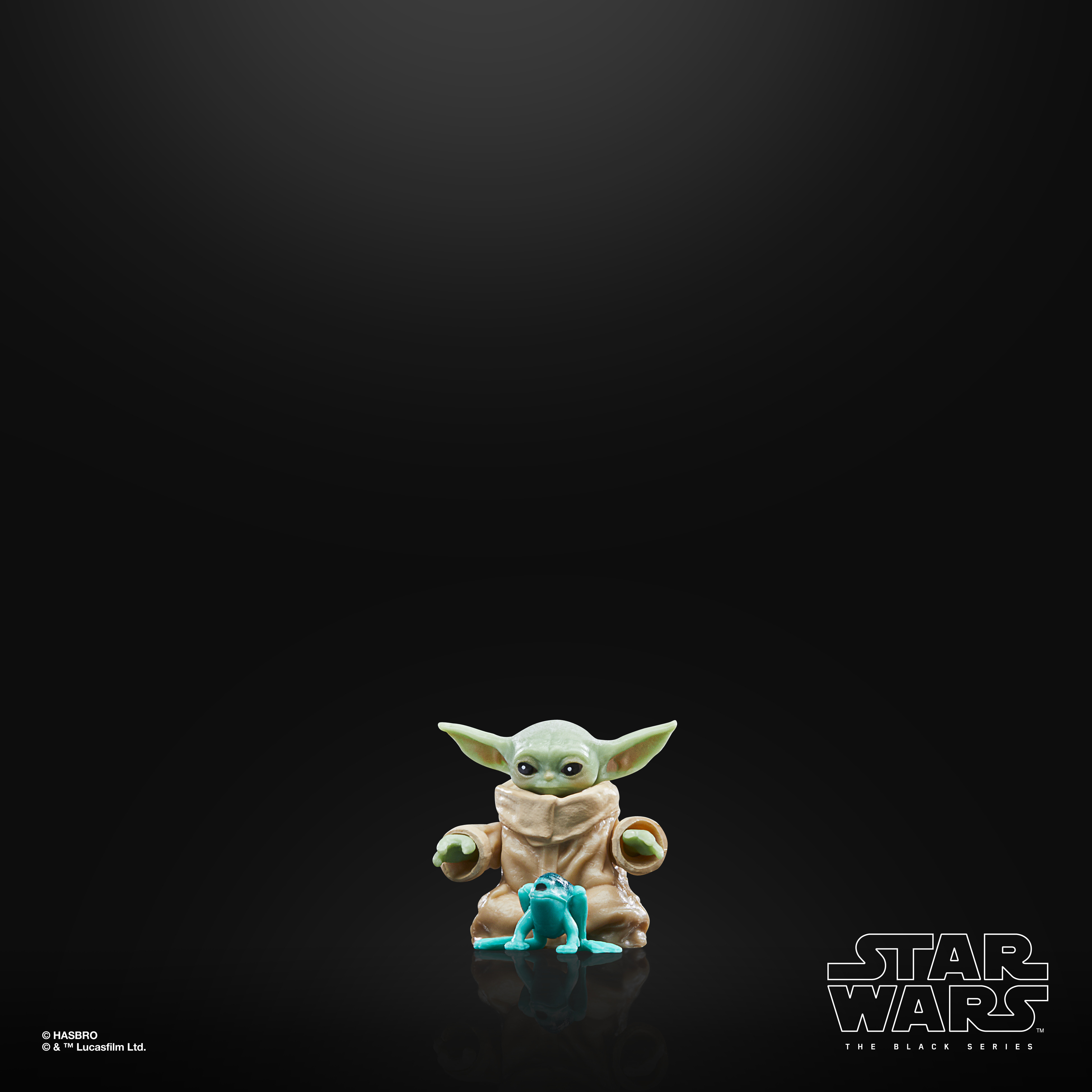 Una statuetta di Star Wars di Grogu che tiene una rana blu. Lo sfondo è nero. La statuetta è di The Black Series.