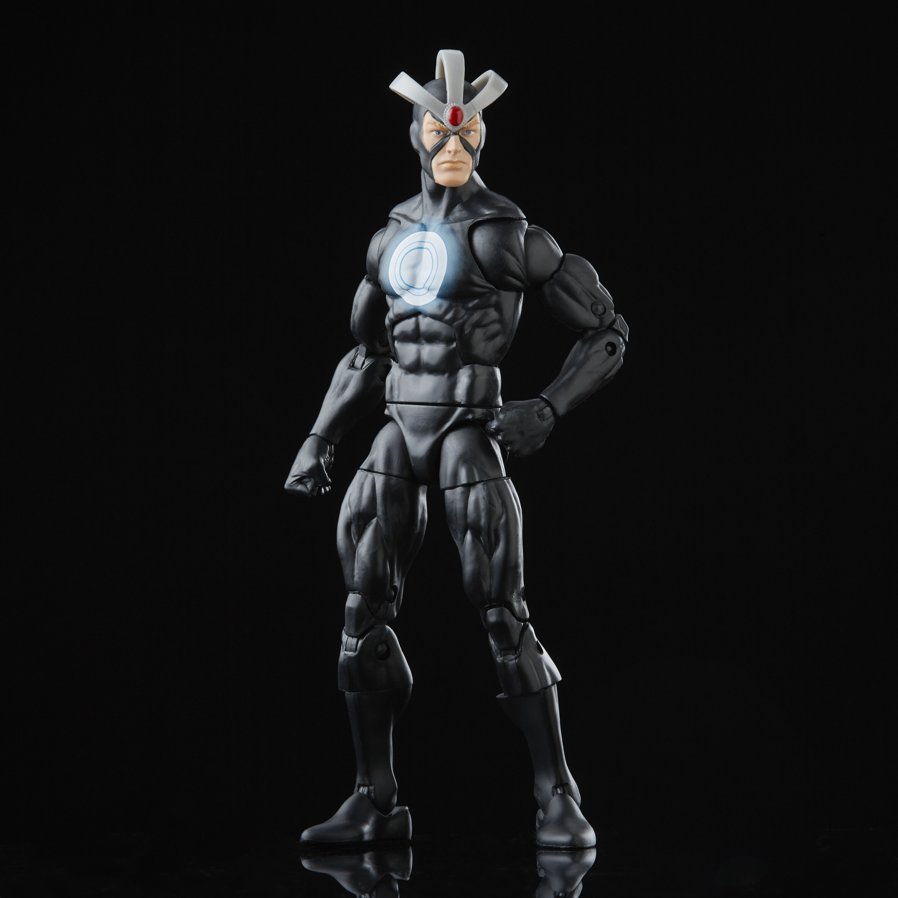 Action figure di un supereroe in tuta nera con copricapo bianco e simbolo luminoso sul petto, su sfondo nero.