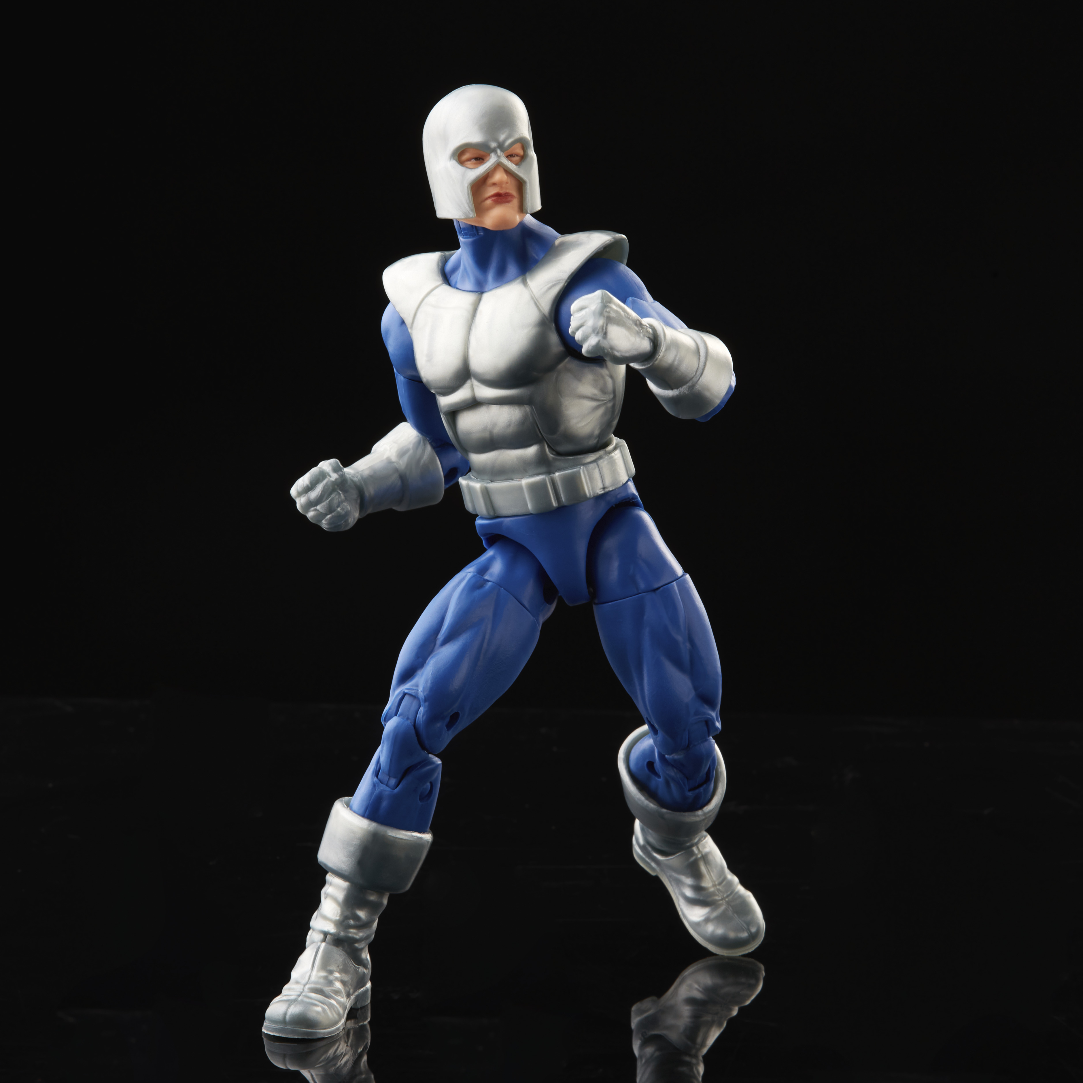 Action figure di un supereroe blu e argento, in posa su una superficie nera riflettente.