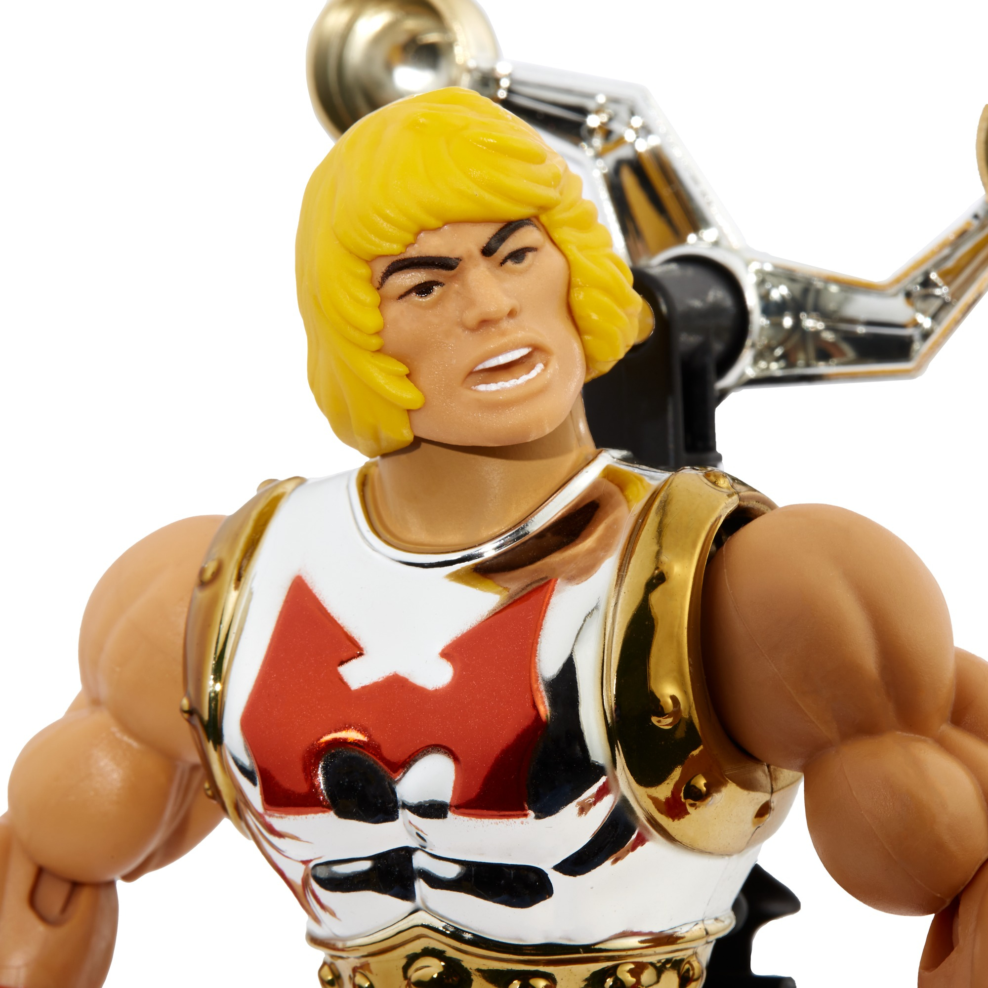 Primo piano di un action figure di He-Man. Ha capelli biondi, un pettorale bianco con logo rosso e dettagli dorati.