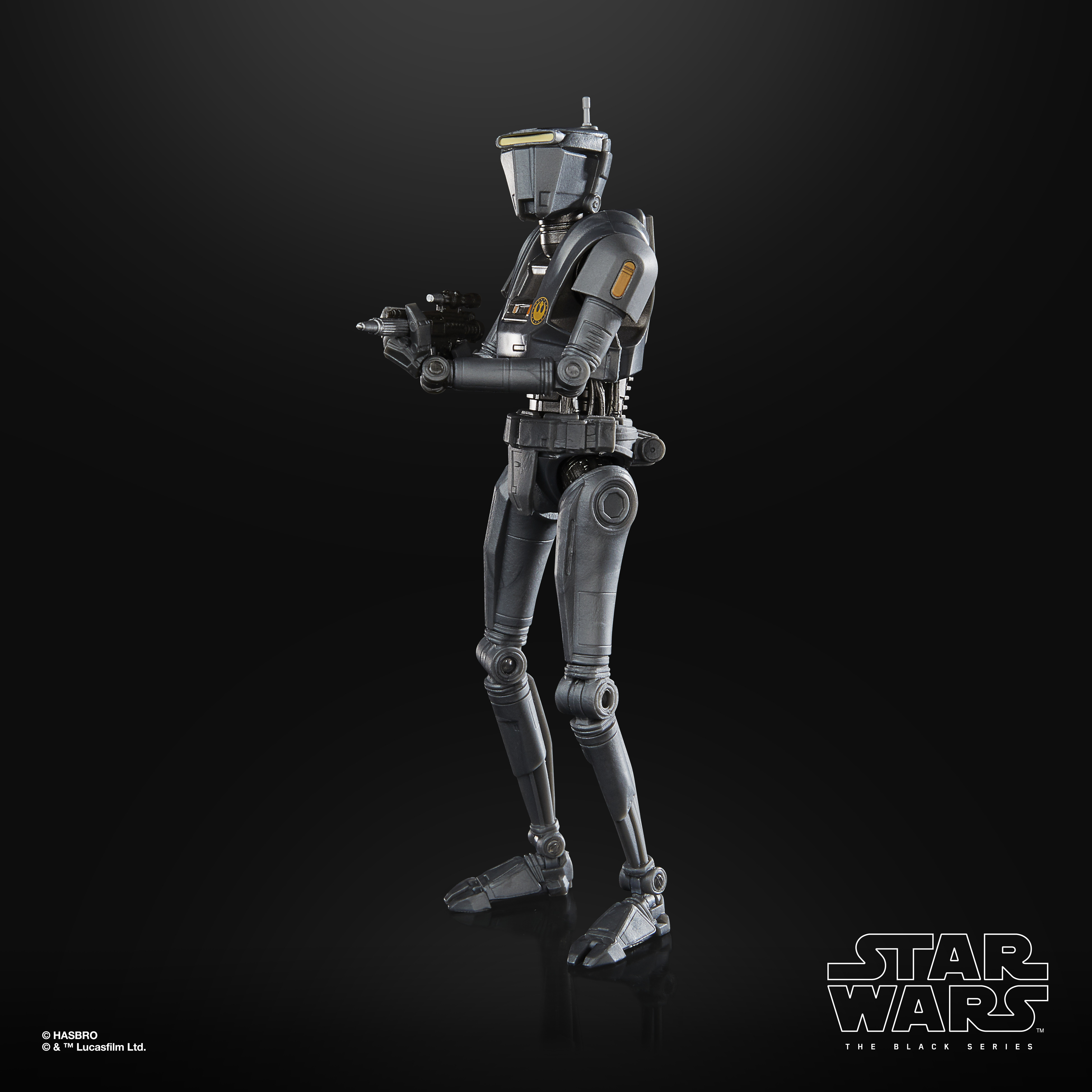 Una figura di droide grigio di Star Wars è in piedi su una superficie nera. Tiene un'arma. Anche lo sfondo è nero.