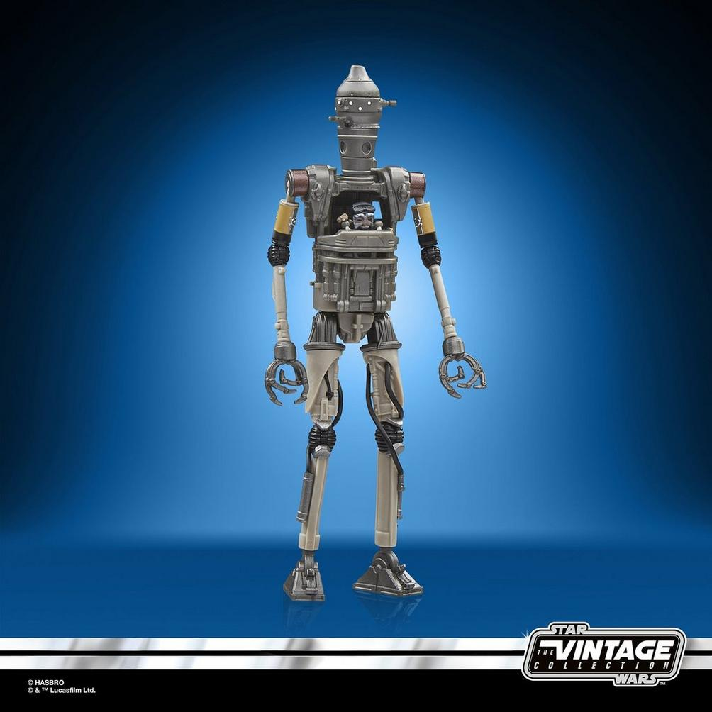 Figurka akcji Star Wars IG-11 stoi na tle niebieskiego gradientu. Jest to metalowy robot z ruchomymi kończynami i szczegółową jamą klatki piersiowej.