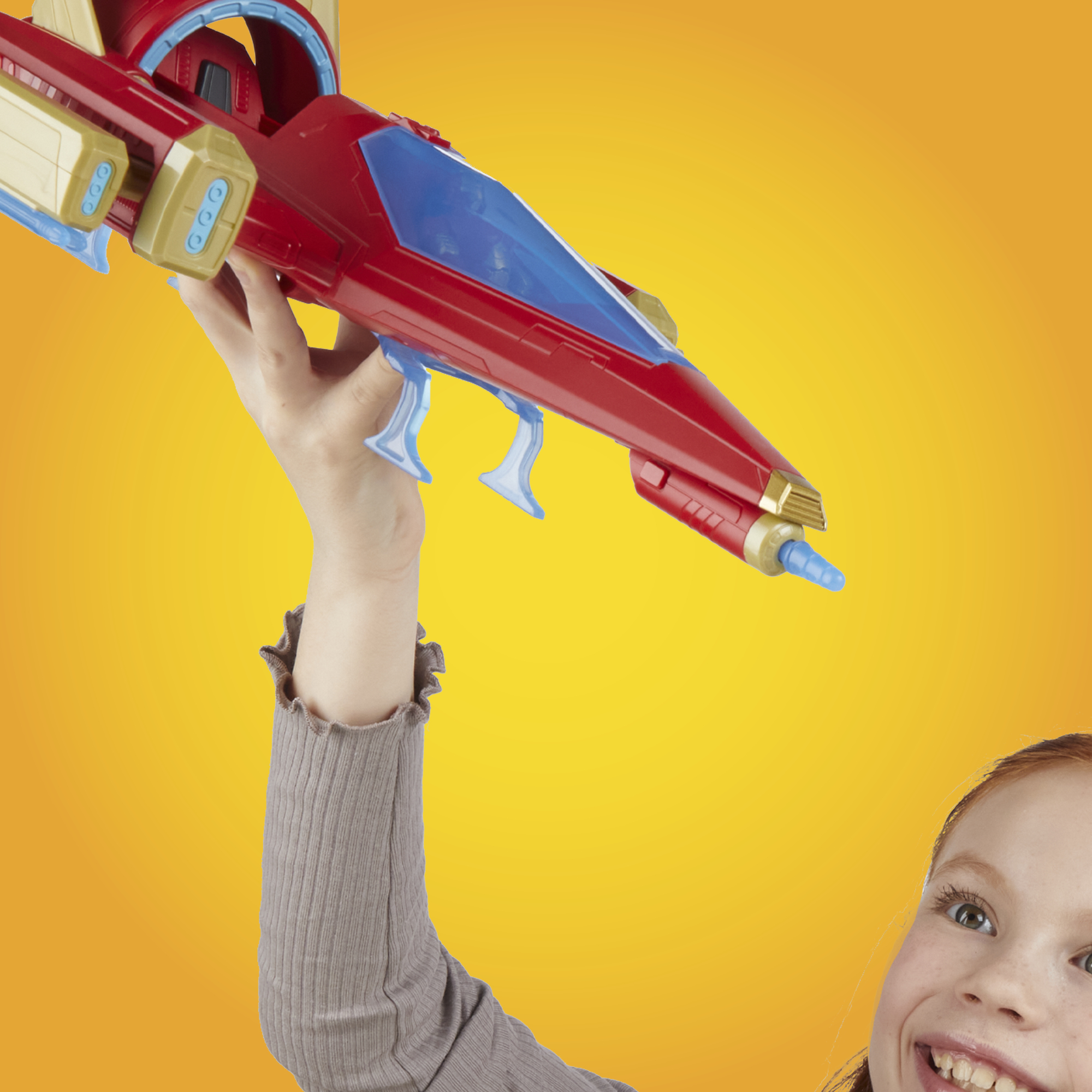 Dziewczyna trzyma czerwoną zabawkę-statek kosmiczny na żółtym tle. Uśmiecha się, patrząc na zabawkę.