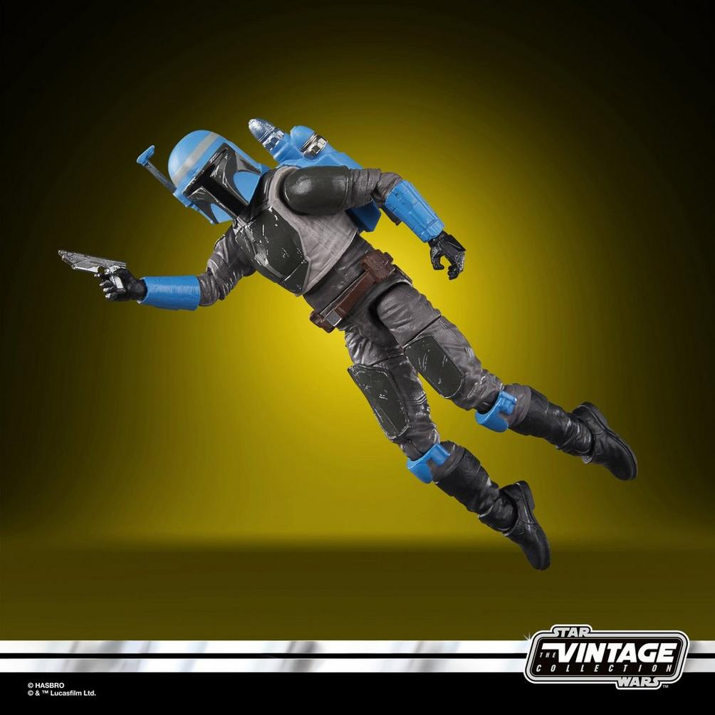 Uçuşan bir Mandalorian'ın aksiyon figürü, bir patlayıcı tutuyor. Mavi ve gri zırh giyiyor, jetpack'i var. Arka plan sarı.