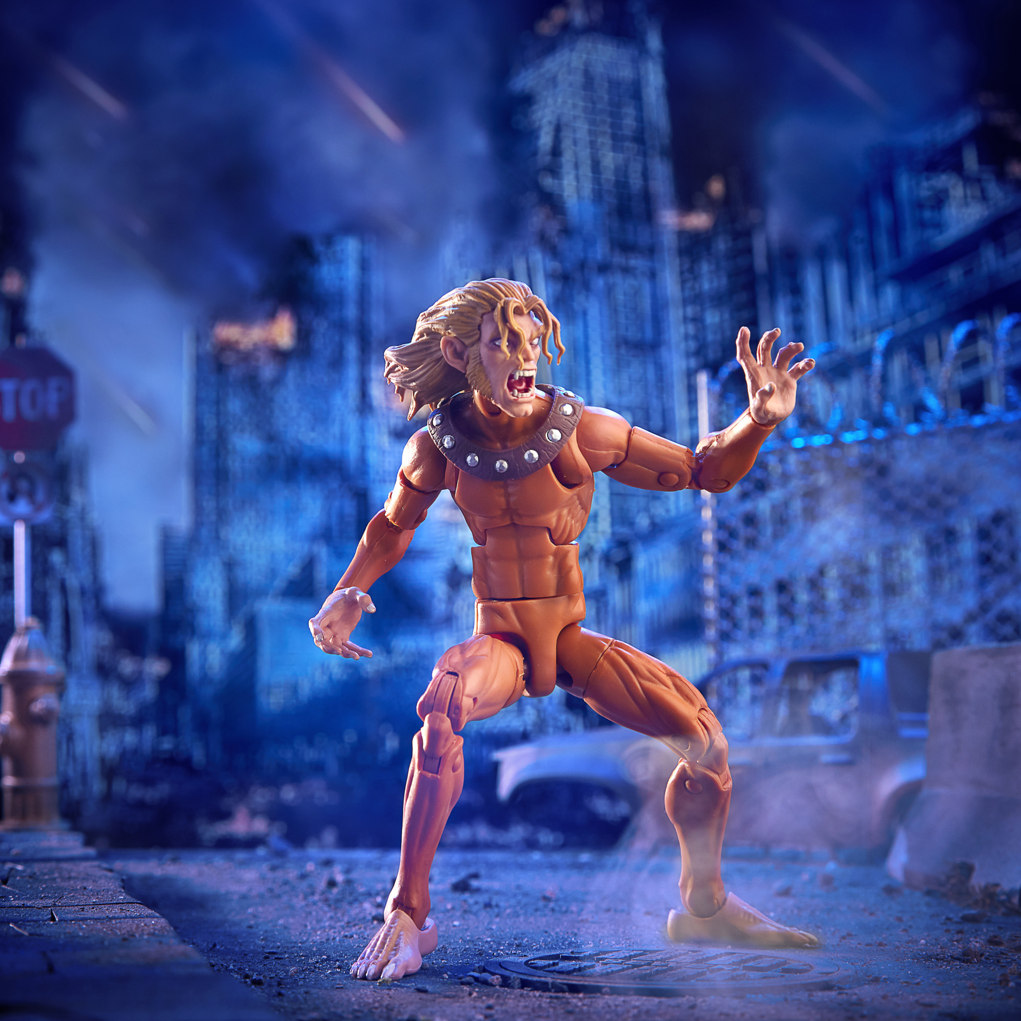 Action figure di un personaggio muscoloso con artigli, in una città con un segnale di stop e un idrante.