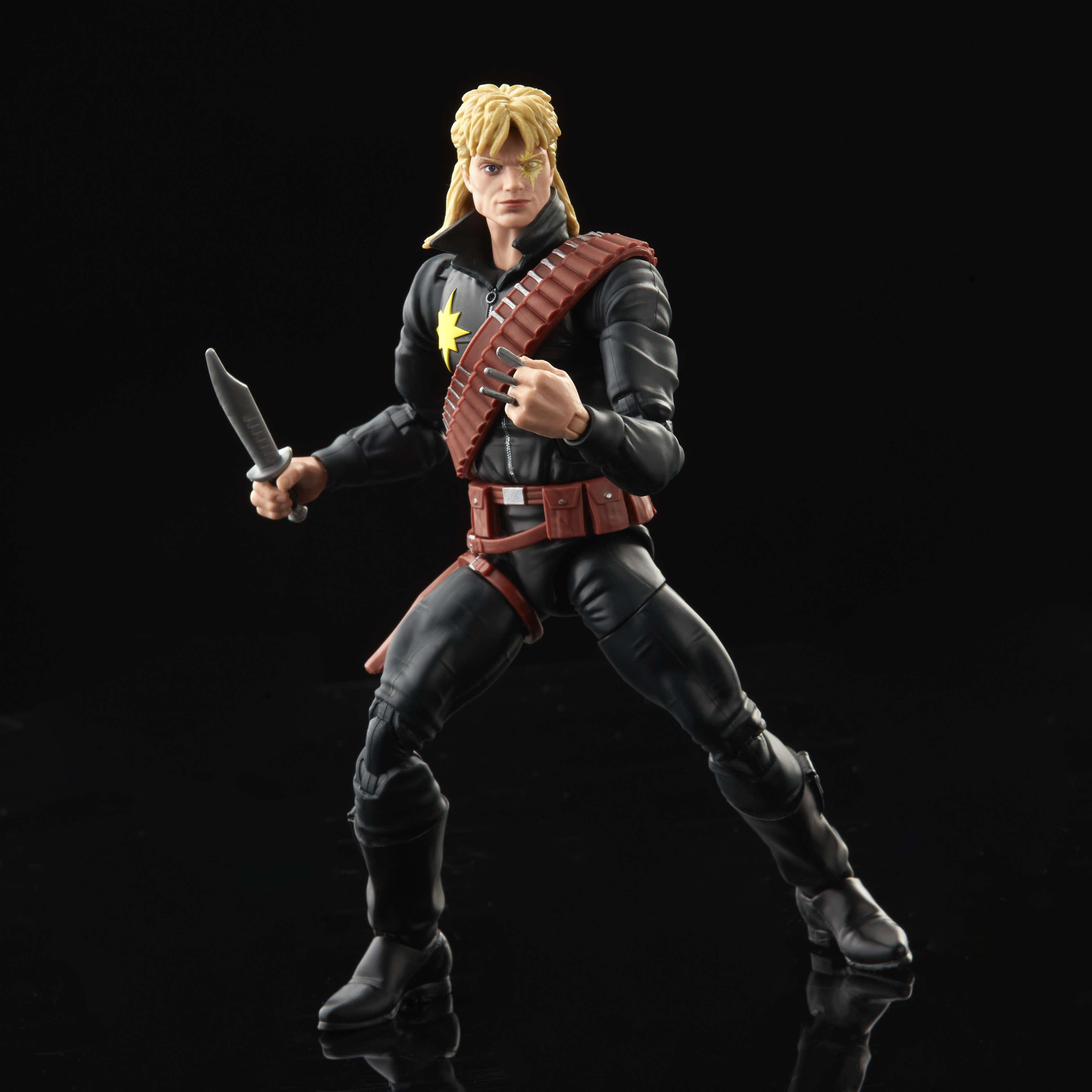 Action figure di un uomo in abito nero, con un coltello. Ha i capelli biondi e una stella sul petto.