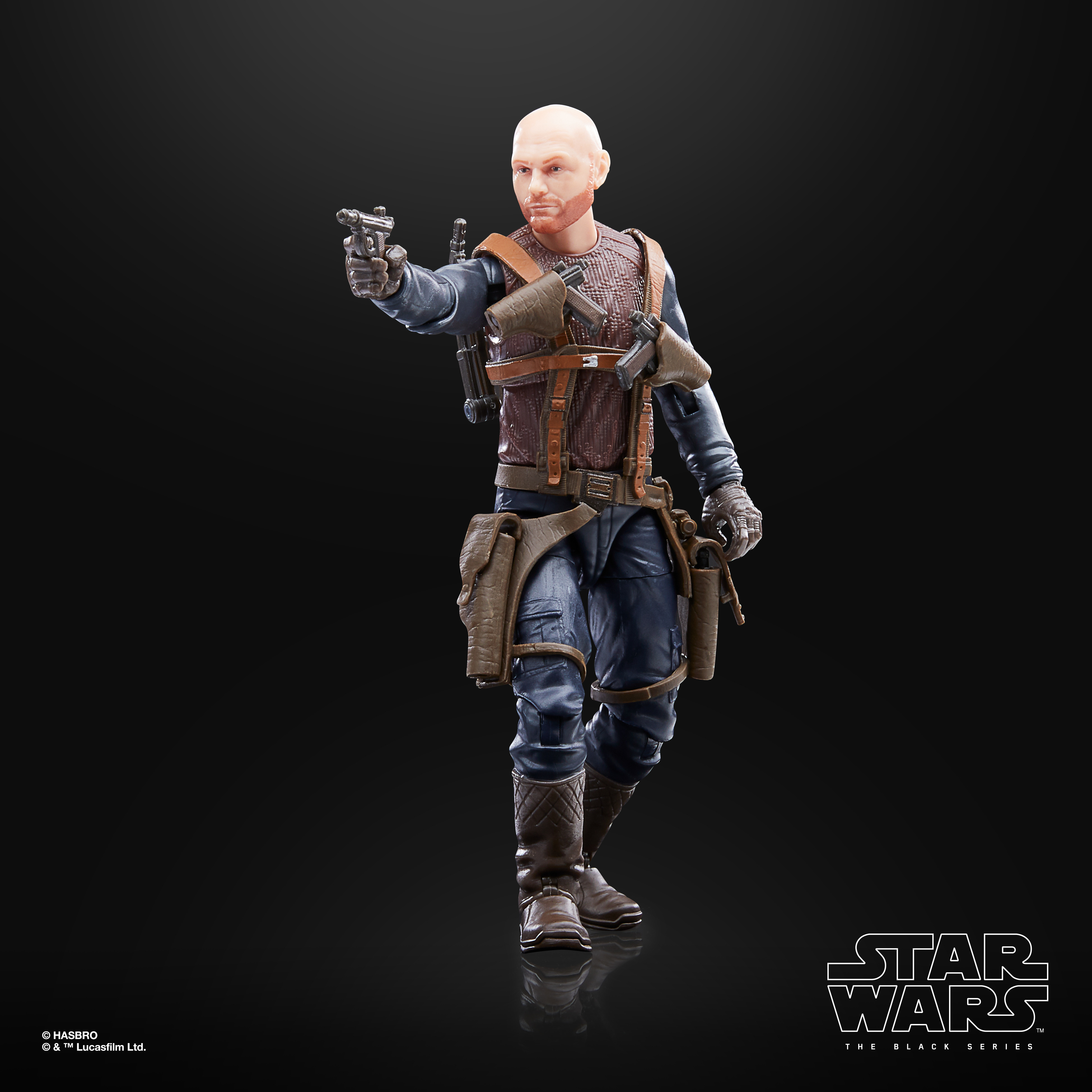 Eine kahle Figur in brauner und blauer Kleidung, die eine Waffe hält, steht vor schwarzem Hintergrund. Star Wars-Logo sichtbar.