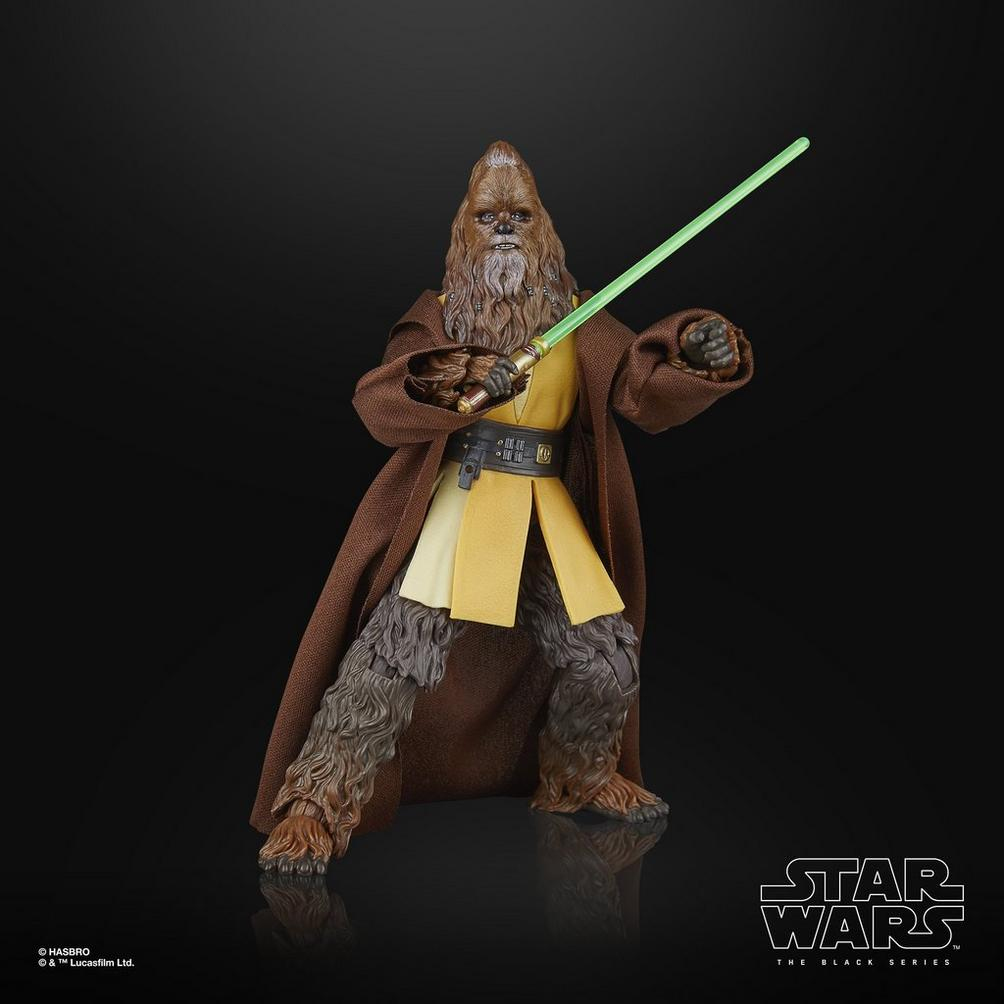 Una figura di Chewbacca con una spada laser verde. Indossa un mantello marrone e una camicia gialla, su sfondo nero.