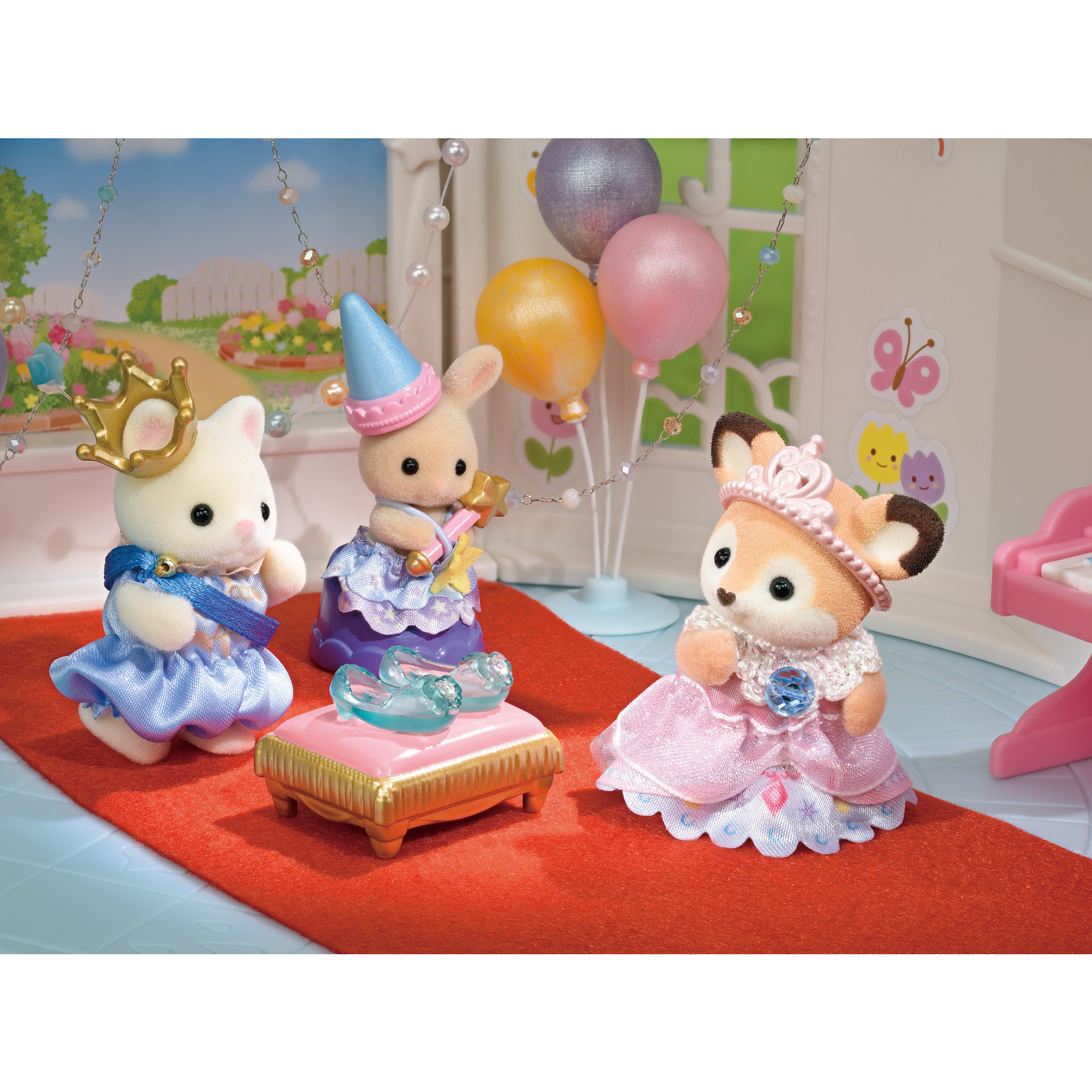 Tres figuras de animales vestidas de princesas. Globos y decoraciones en el fondo. Una alfombra roja al frente.